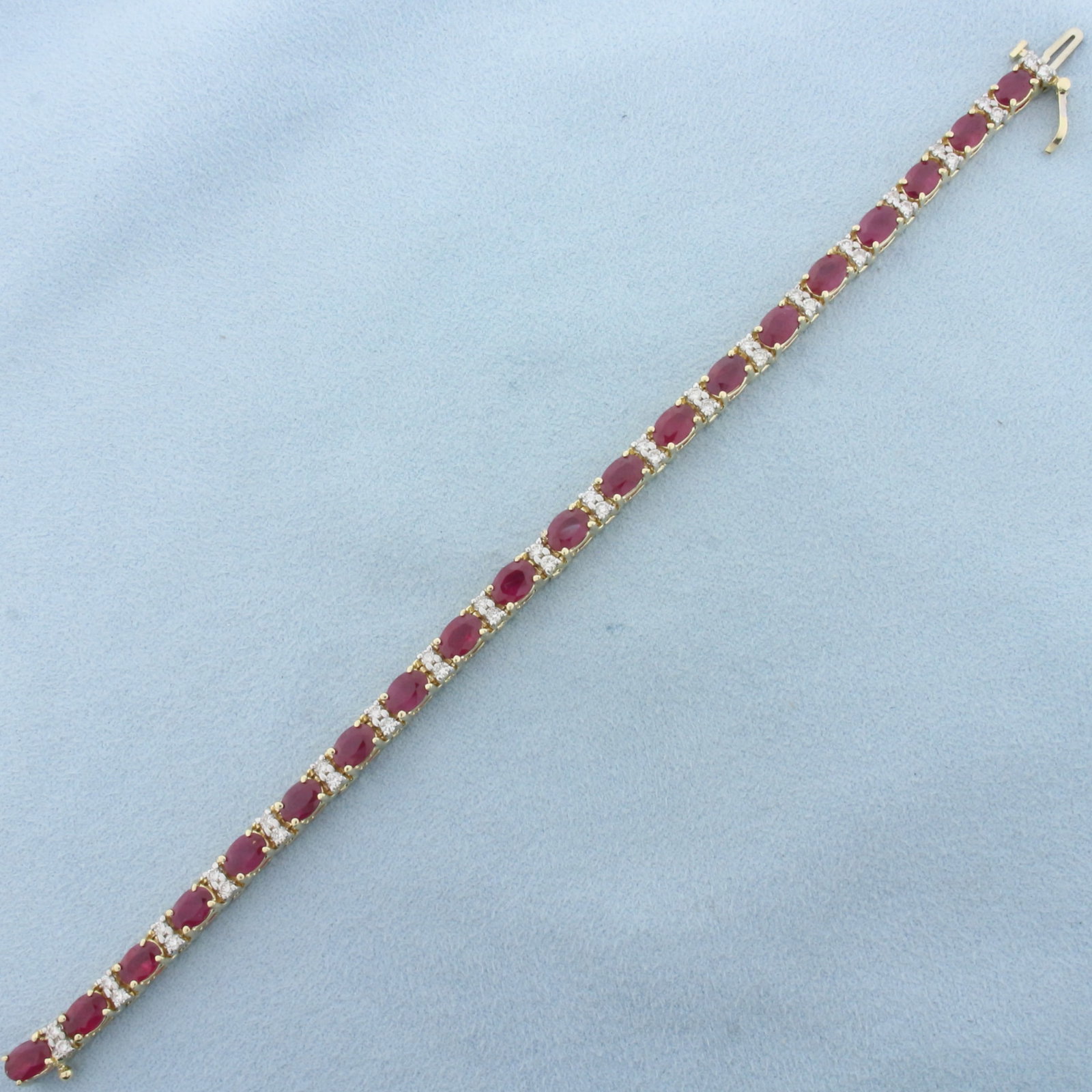 Ruby and Diamond Tennis Bracelet in 14k Yellow Gold: In 14k Yellow Gold. Contains twenty high quality natural 6mm Ruby gemstones, 10ct TW, with intense color and excellent clarity. Also contains forty .03ct diamonds, SI clarity/H color. 7 1/8 inch long.