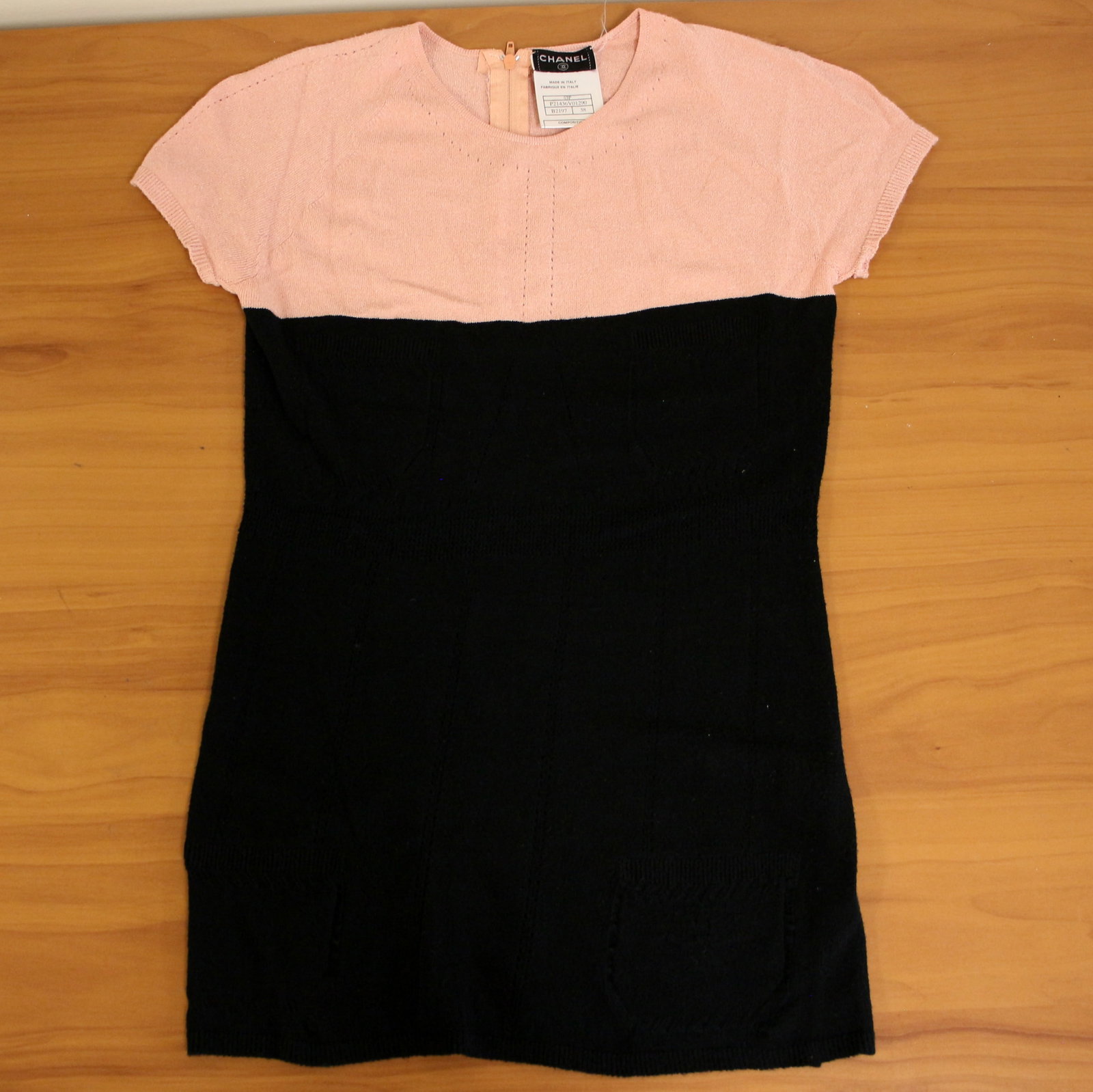 Chanel 03P Knit Short Sleeved Top 38: Season 03P. Serial number P21436V01290, B2197. Size 38. Features color blocked pink and black design with faux pockets and iconic CC knitted into the pattern at the bottom. 83% viscose, 17% polyester.