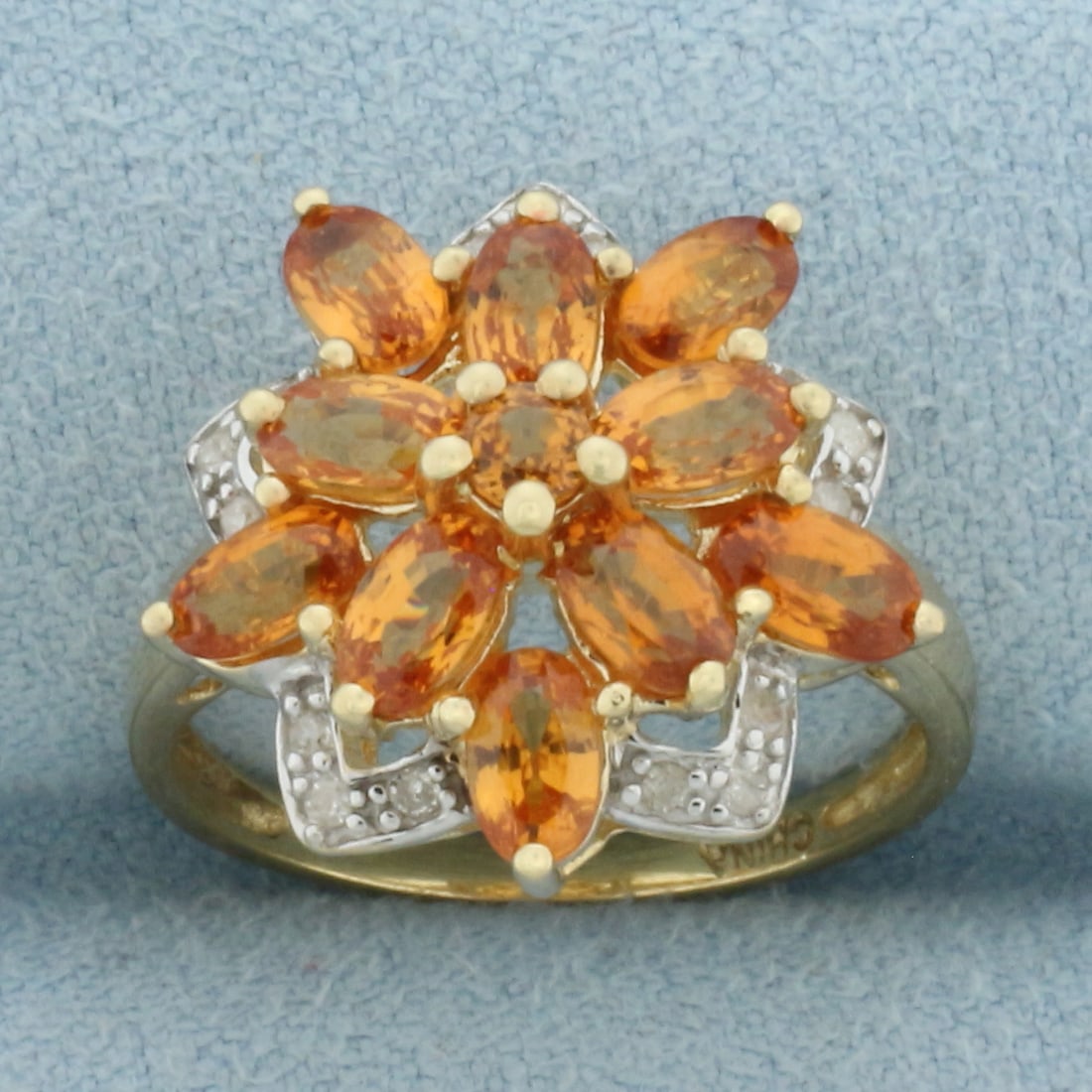 Spessartite Garnet and Diamond Ring in 10k Yellow Gold: In 10k Yellow Gold. Contains ten 5x3mm oval and one 3mm round high quality natural Spessartite Garnet gemstones, approximately 2.5ct TW, with vibrant color and excellent clarity. Also contains fifteen
