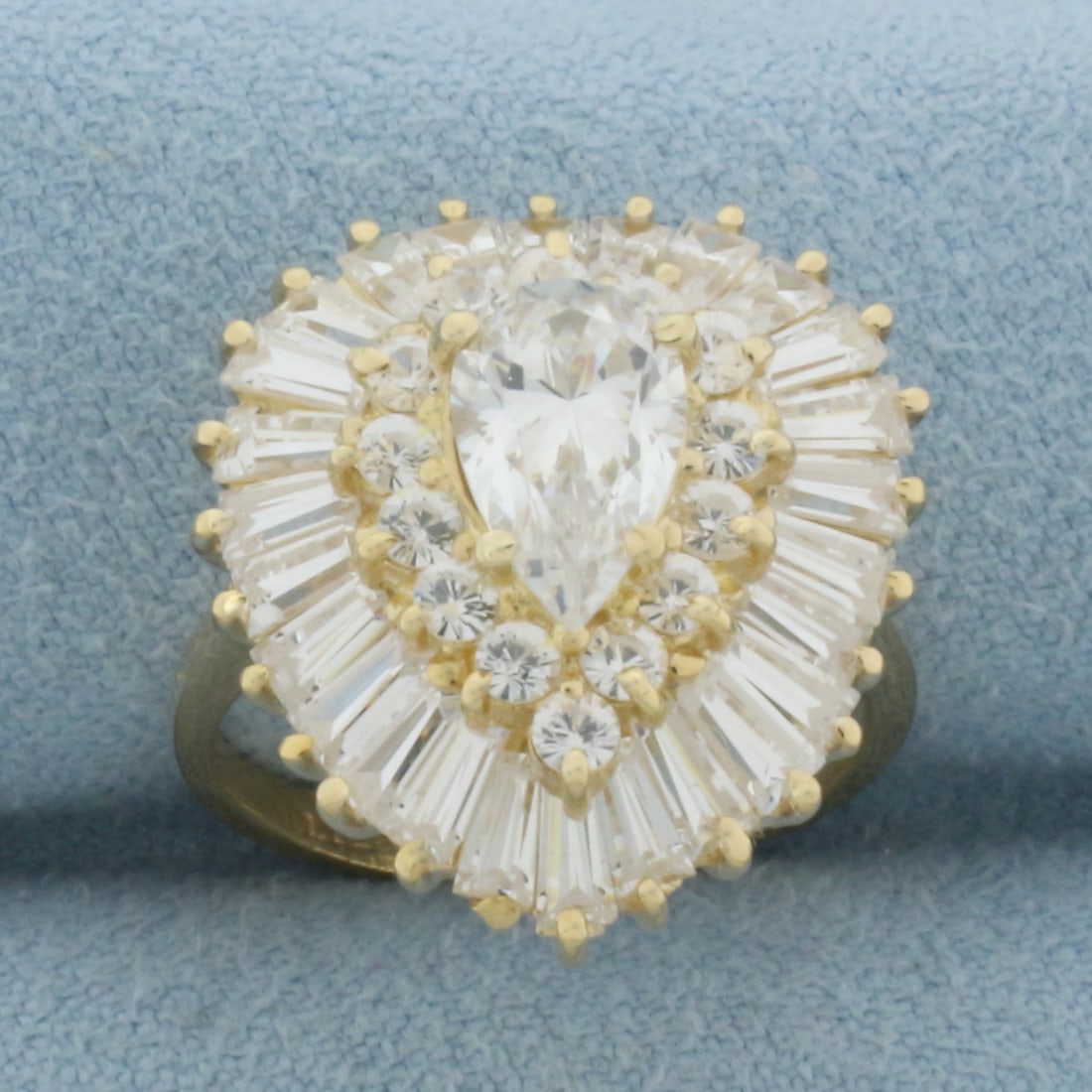 CZ Ballerina Ring in 14k Yellow Gold: In 14k Yellow Gold. Contains one 9x5.5mm high quality pear cut Cubic Zirconia gemstone with excellent cut and clarity. Also contains fourteen 2mm round and twenty-six 4x2mm tapered baguette CZ