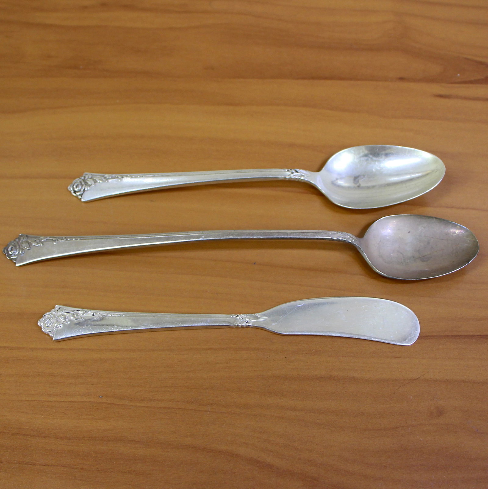 Oneida Heirloom Damask Rose Sterling Silver Flatware Set of 3: .925 Sterling Silver. One teaspoon (61/8"), one iced teaspoon (7 1/2"), one flat handle solid butter spreader (5 7/8"). 83.1g