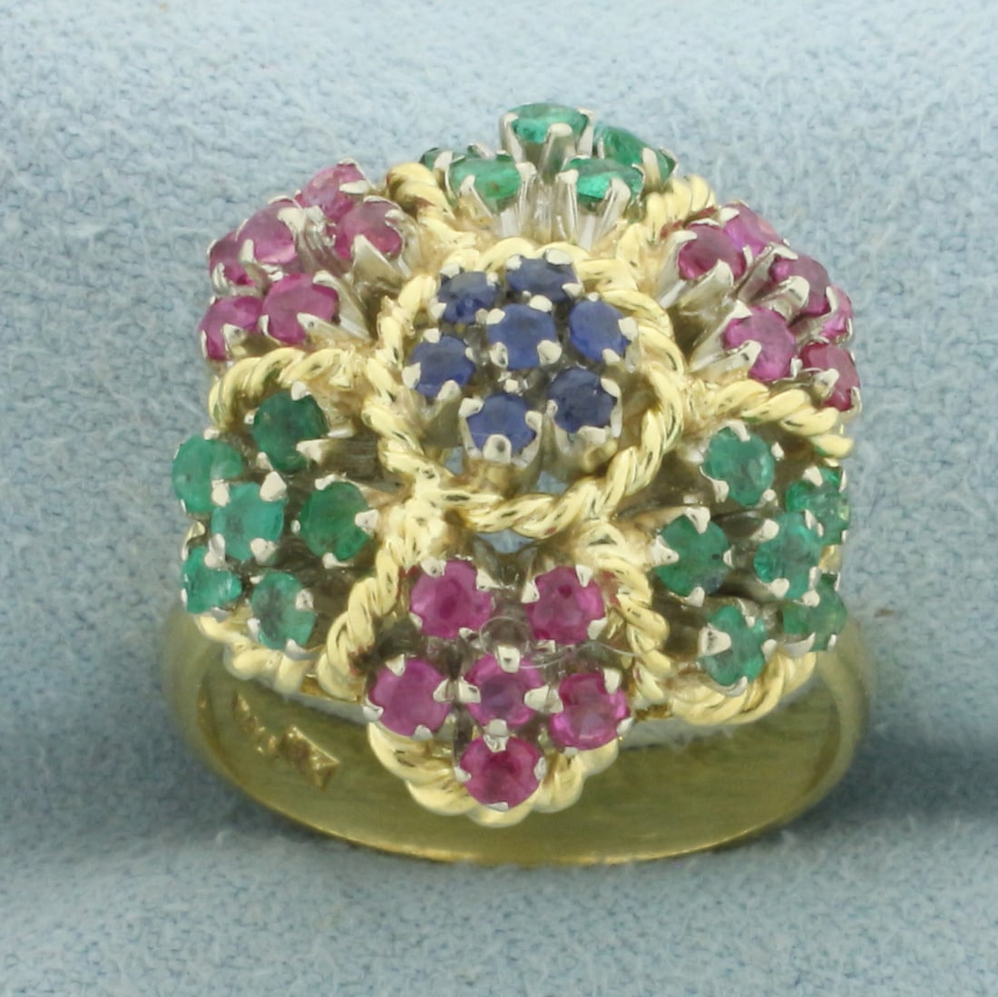 Italian Sapphire Ruby and Emerald Flower Ring in 18k Yellow Gold: In 18k yellow gold. Contains seven high quality natural 2mm Sapphire gemstones, 18 high quality natural 2.25mm Ruby gemstones, and 18 high quality natural 2.25mm Emerald gemstones, all with excellent 