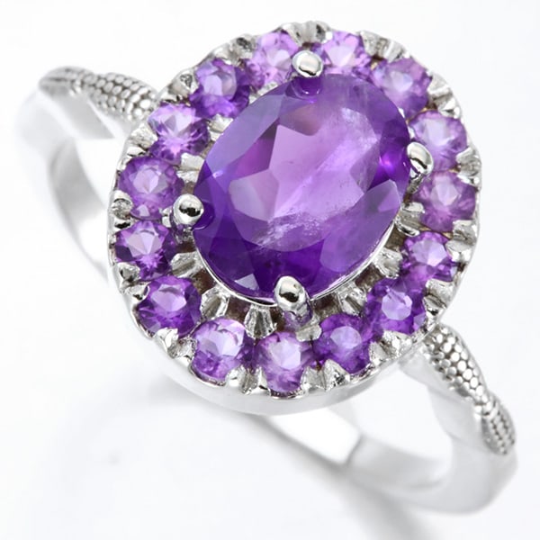 Amethyst Halo Ring in Sterling Silver: In platinum over .925 sterling silver. Contains one large deep purple amethyst gemstone, 1.1cts, surrounded by a halo of fifteen amethyst gemstones, 0.5ctw. Size 6. 3.g