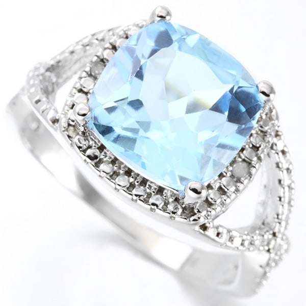 Cushion Cut Blue Topaz and Diamond Ring in Sterling Silver: In platinum over .925 sterling silver. Contains one large 5.1ct cushion cut blue topaz gemstone, accented by two diamonds, .01ctw. Size 7. 4.3g