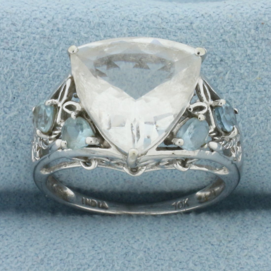 White Topaz and Aquamarine Statement Ring in 10k White Gold: In 10k White Gold. Contains one trillion cut 12mm natural white topaz with excellent clarity. Also contains four 4mm Aquamarine gemstones with bright color and excellent clarity. Size 7. 3.5g.