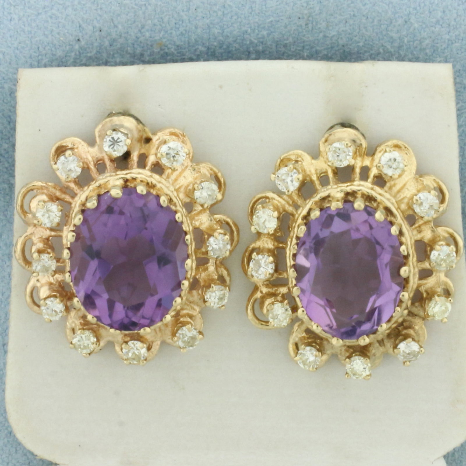 Vintage Amethyst and Diamond Halo Earrings in 14k Yellow Gold: In 14k Yellow Gold. Contains two 13x10mm high quality oval cut natural Amethyst gemstones, approximately 10ct TW, with vibrant color and excellent clarity. Also contains twenty-four .03ct high quality
