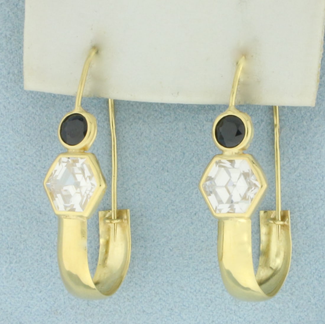 Italian Sapphire Drop Earrings in 18k Yellow Gold: In 18k Yellow Gold. Contains two 5mm high quality Sapphire gemstones with deep color. Also contains two 9mm high quality hexagon cut CZ gemstones with excellent cut and clarity for added brilliance. 1