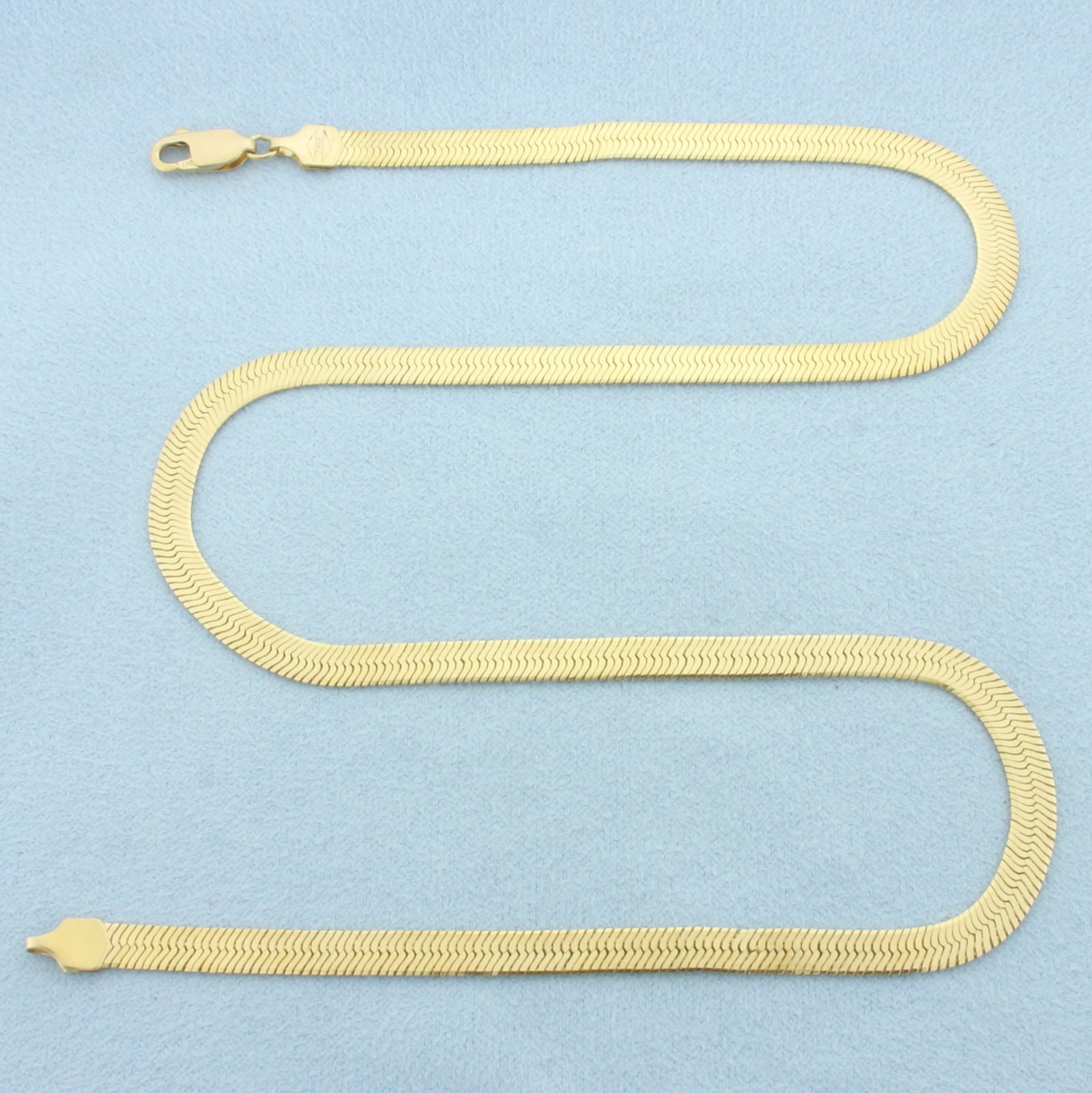 16 Inch Herringbone Link Chain Necklace in 14k Yellow Gold: In 14k Yellow Gold. 16 inches long. 4.3mm wide. Lobster clasp. 10.2g.