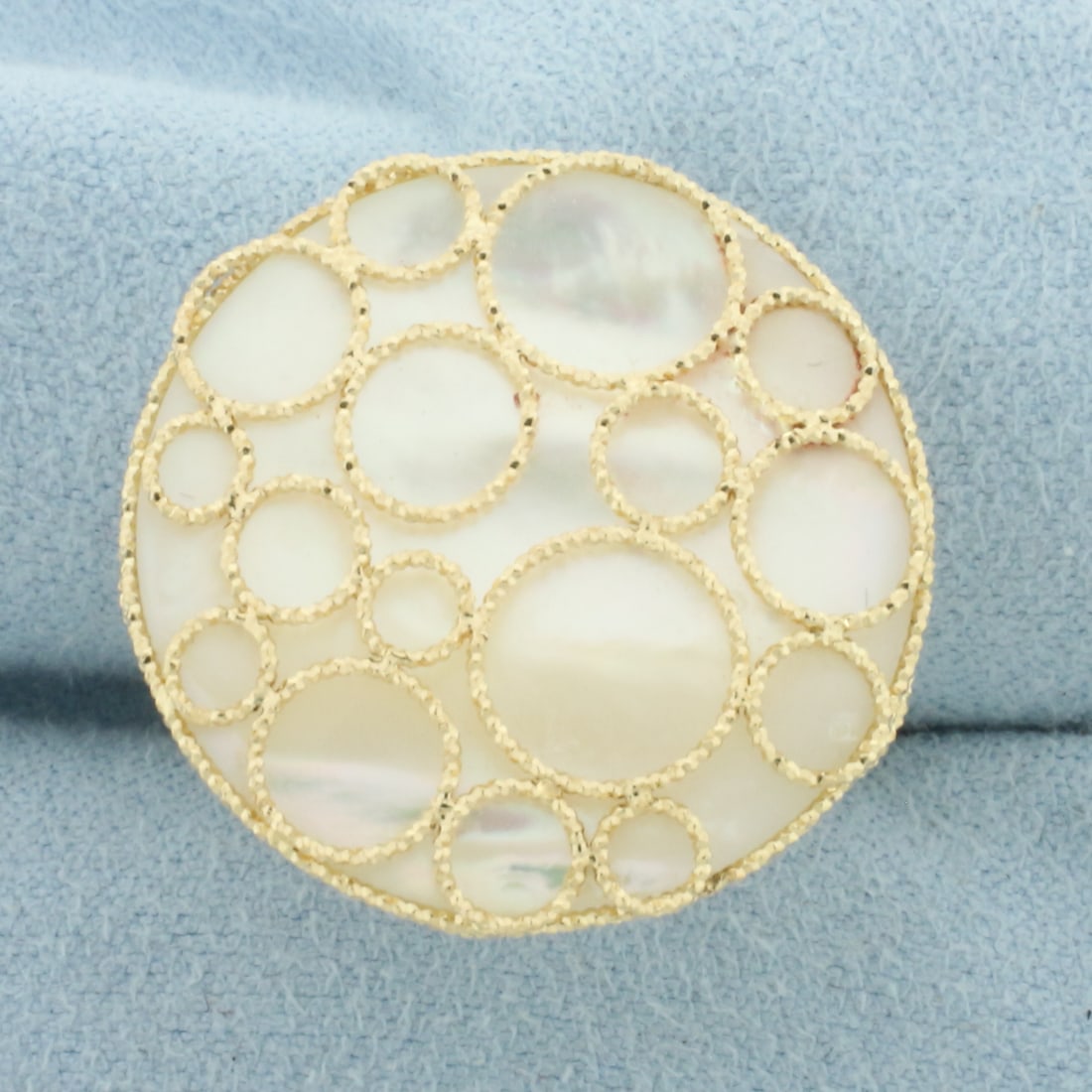 Mother of Pearl Filigree Large Statement Ring in 14k Yellow Gold: In 14k yellow gold. Contains one Mother-of-Pearl gemstone, 1 inch diameter, with iridescent undertones and high luster. Beautiful metal work encases the gem. Size 8.5. 5.9g
