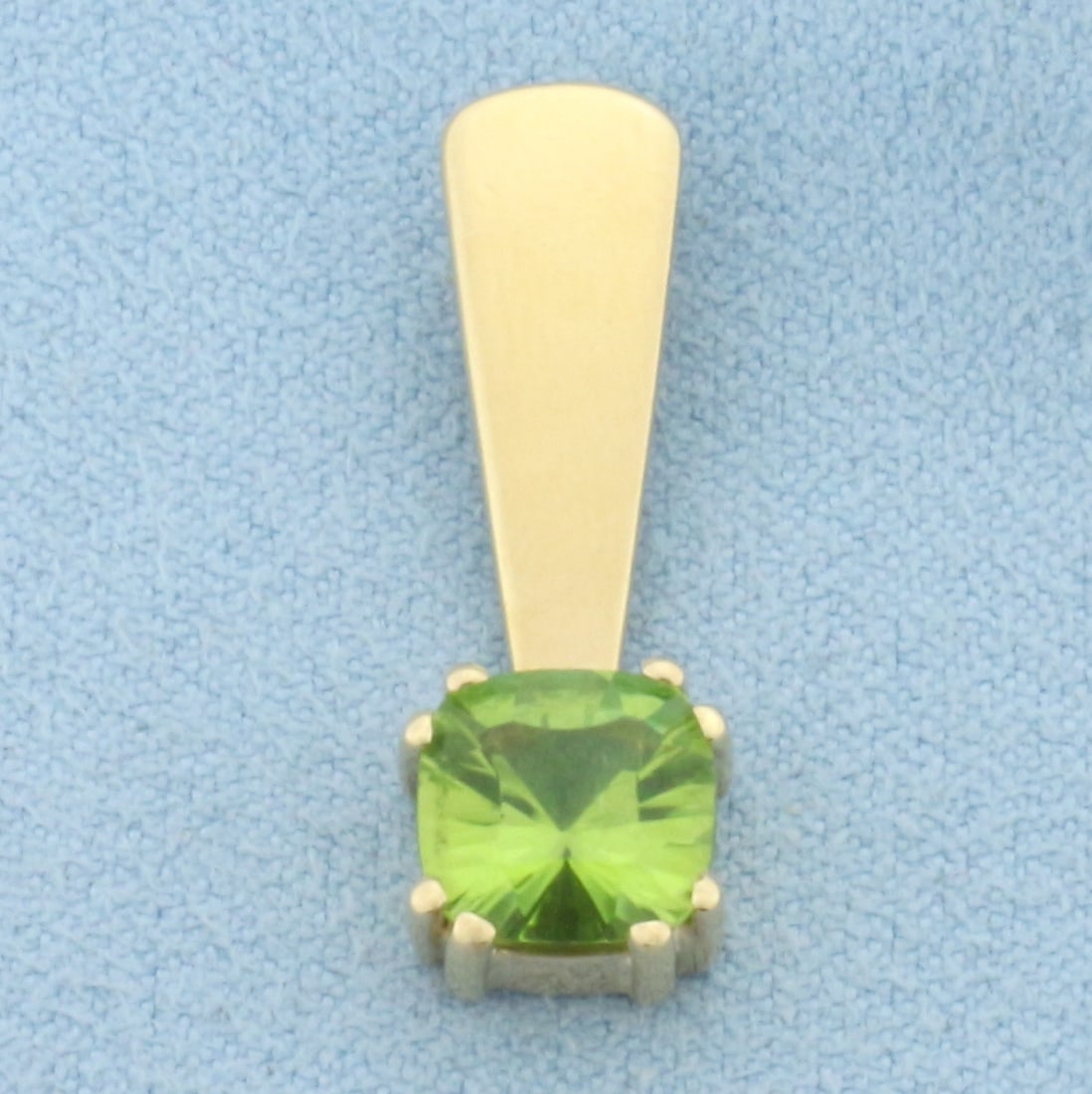 Peridot Pendant in 14k Yellow Gold: In 14k Yellow Gold. Contains one 8mm high quality cushion cut natural Peridot gemstone with vibrant color and excellent clarity. 1 inch long. 3/8 inch wide. 2.9g.