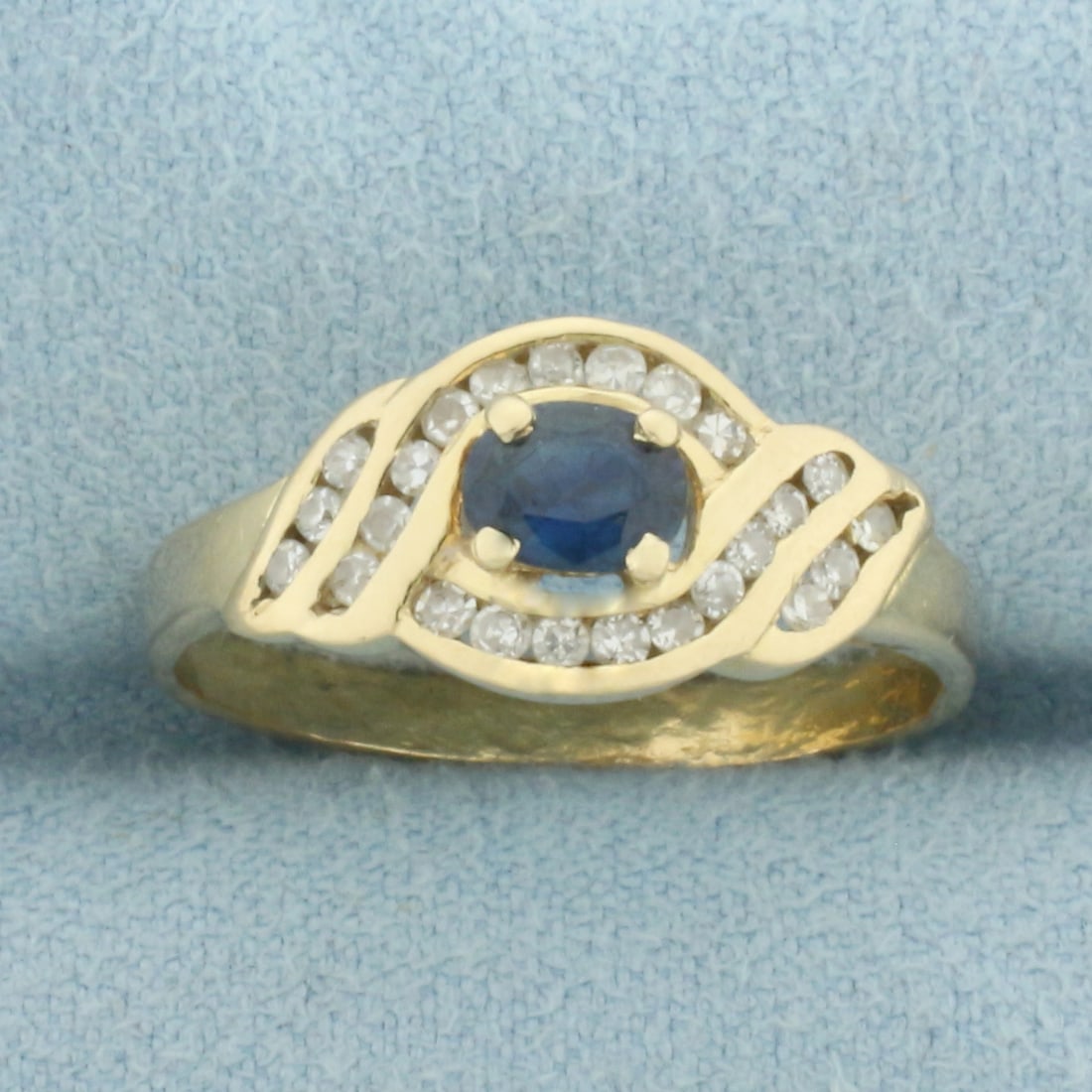 Vintage Sapphire and Diamond Ring in 14k Yellow Gold: In 14k Yellow Gold. Contains one 5mm high quality natural Sapphire gemstone, approximately 1/3ct, with intense color and excellent clarity. Also contains twenty-four high quality 1/2pt diamonds. 8.7mm