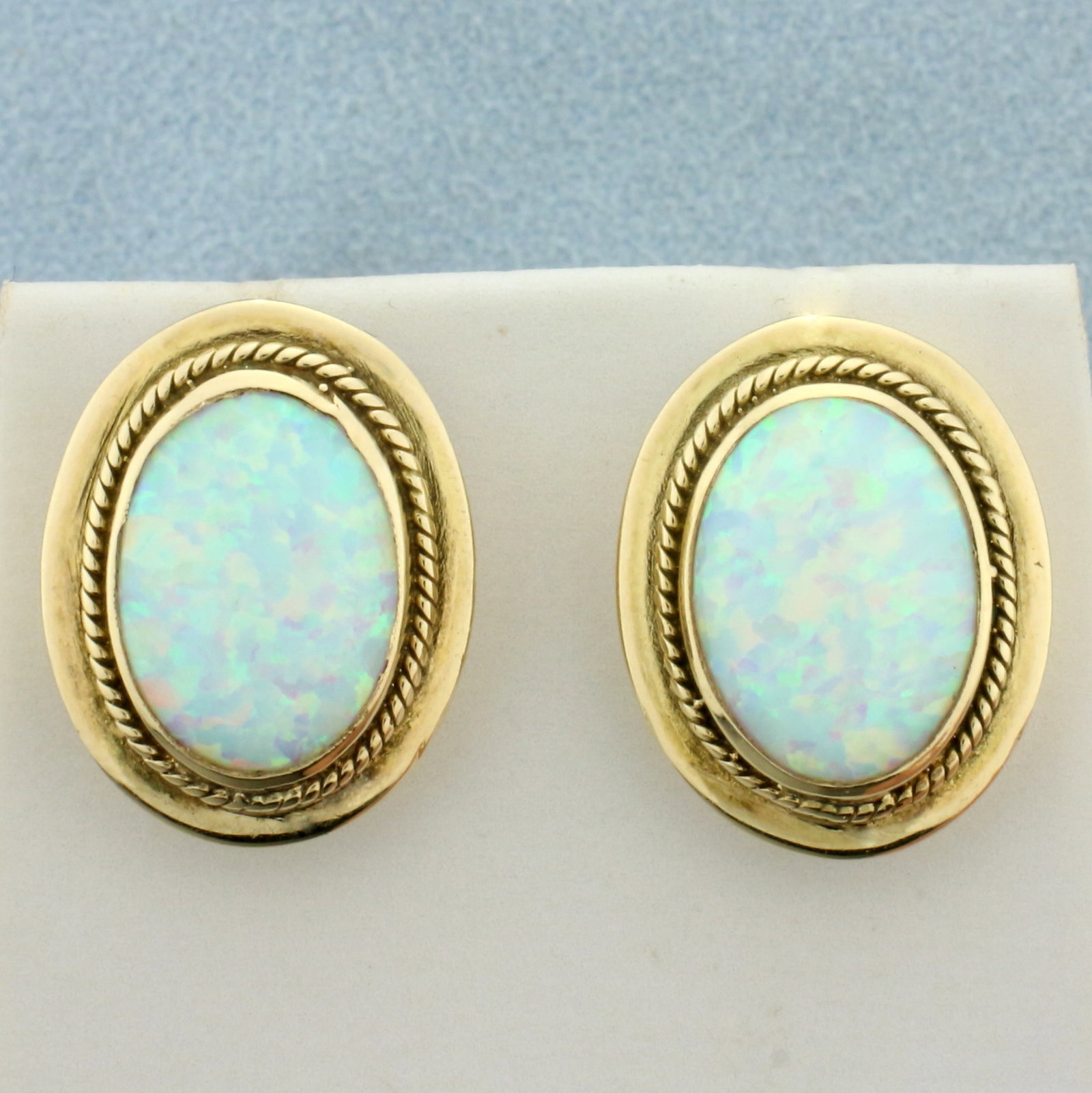 Vintage Ethiopian Opal Button Earrings in 14k Yellow Gold: In 14k yellow gold. Contains two very high quality Ethiopian opal gemstones, 14mm by 11mm, with excellent play of color (blue, green, pink, orange flashes). 19.6mm long, 15.5mm wide. Friction backs. 7