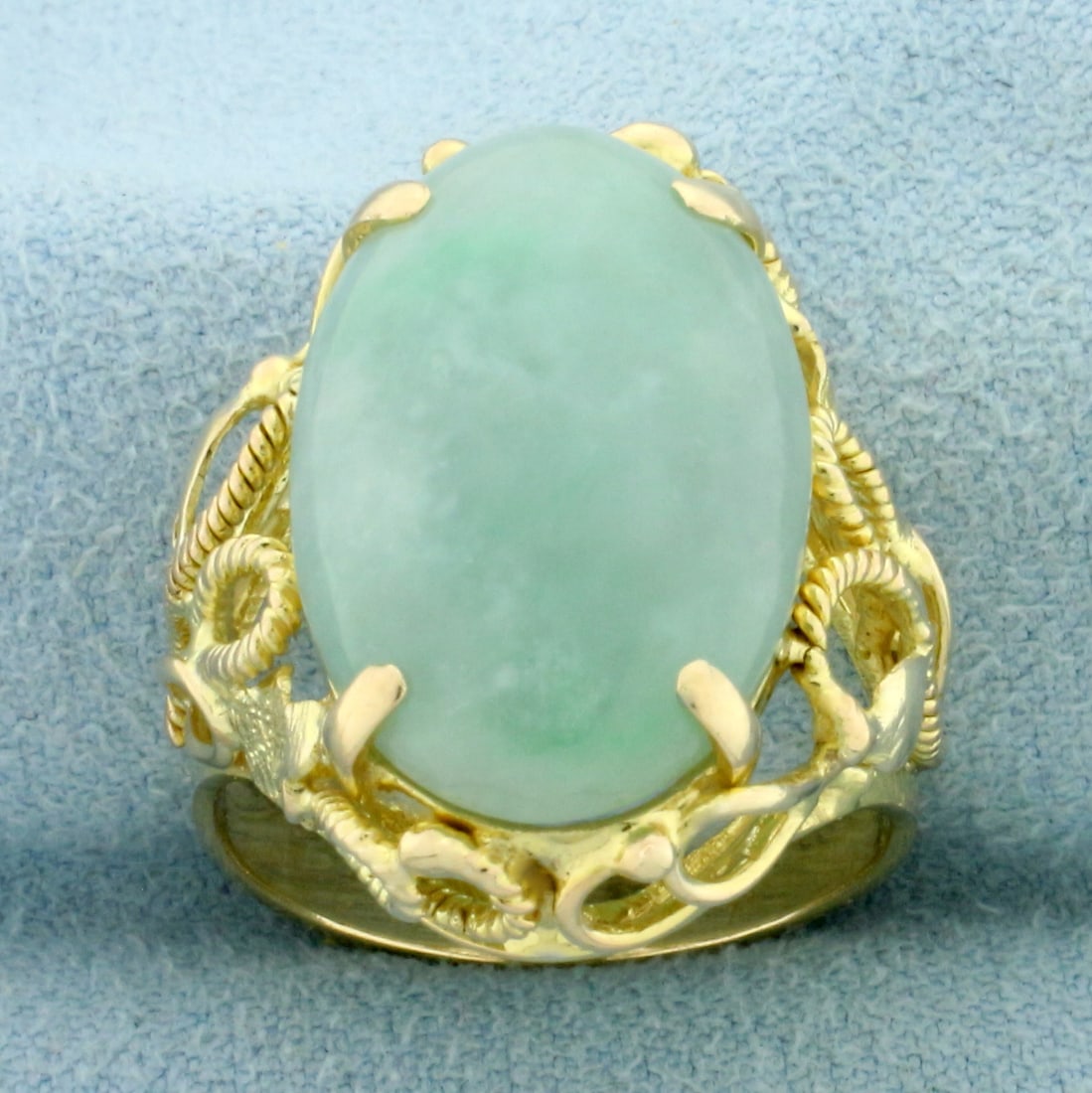 Jade Solitaire Statement Ring in 14k Yellow Gold: In 14k yellow gold. Contains one high quality natural 20mm x 13mm oval cabochon jade gemstone, approximately 15cts, with beautiful light green color. Size: 7.5. 8.0g.