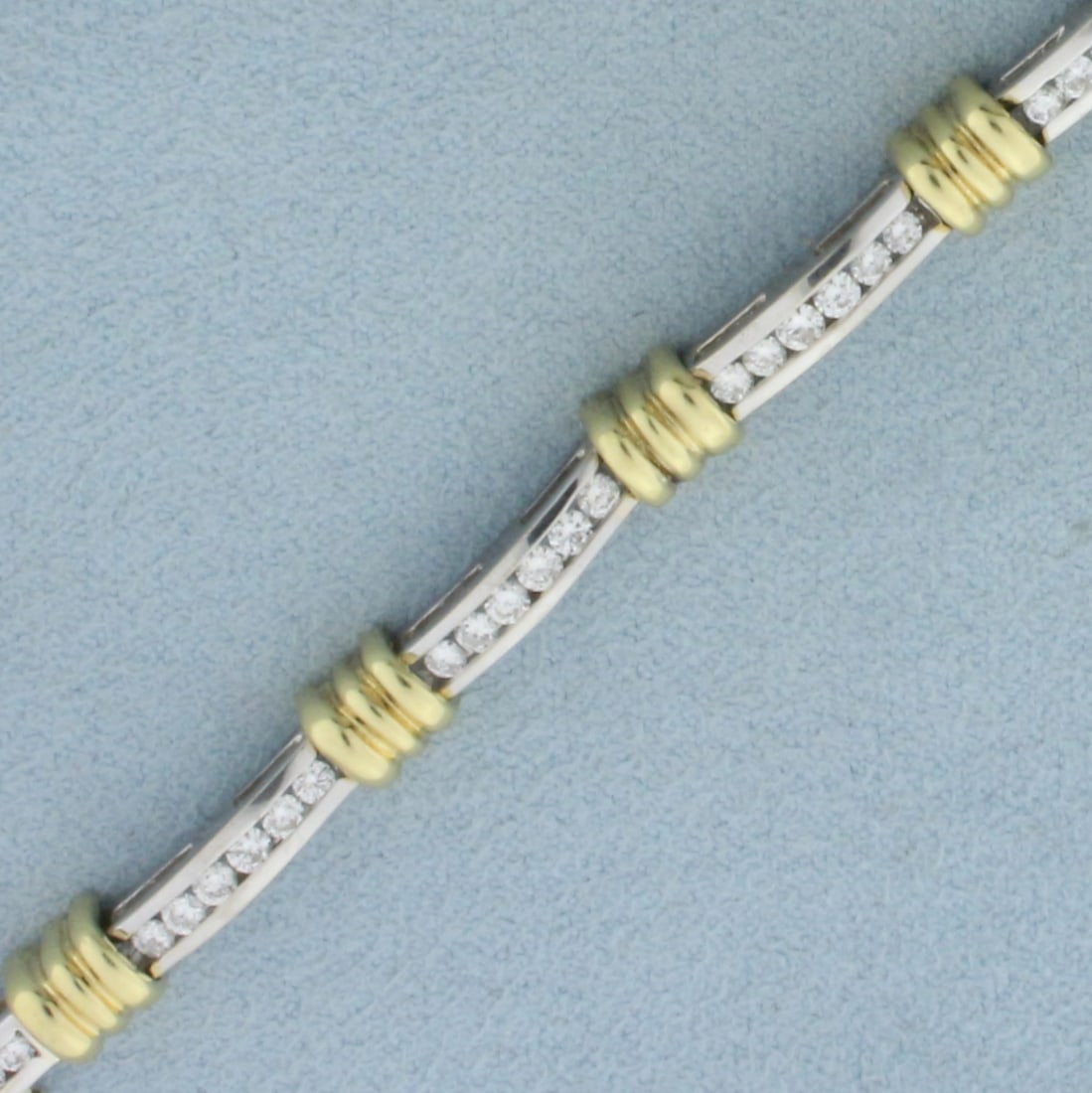 Two Tone Diamond Tennis Bracelet In 18K White And Yellow Gold: In 18k white and yellow gold. Contains 53 high quality diamonds, 2ct TW, VS clarity/H color. 6 1/2 inches long by 5.7mm wide. Concealed clasp with safety latch. 18.2g.