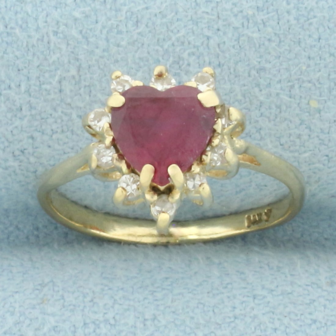 Heart Ruby and Diamond Halo Ring in 14k Yellow Gold: In 14k yellow gold. Contains one high quality natural 6mm heart shaped Ruby gemstone with intense color. Also contains ten high quality .01ct diamonds, SI clarity/H color. Size: 4. 2.0g.