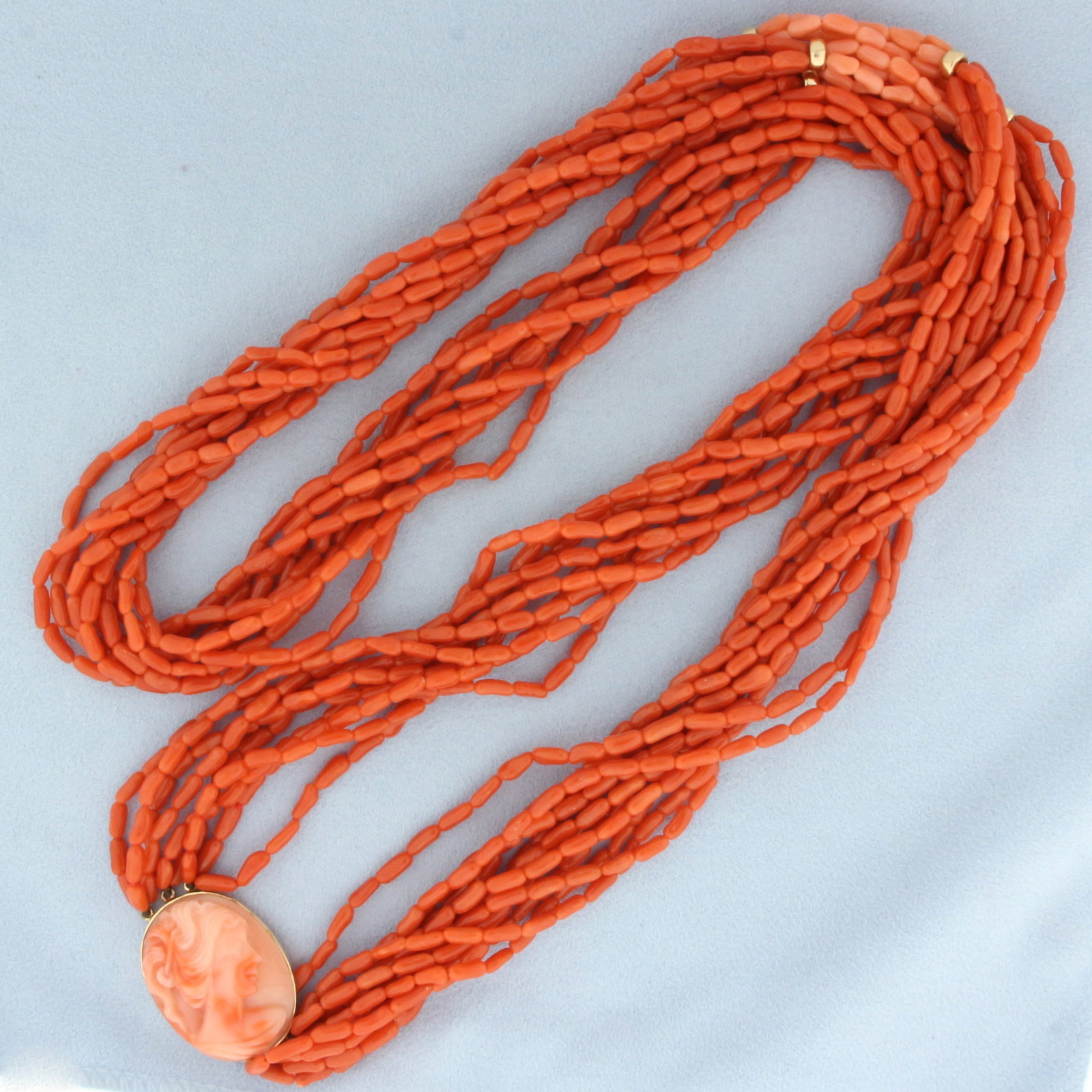 Vintage Red Coral Multi-Strand Cameo Necklace in 14k Yellow Gold: In 14k yellow gold. 31 inches long. Hand carved Cameo is 7/8 inches wide. Multi strand red coral with lighter red/pink coral accent section and 5mm gold beads. 98.6g.