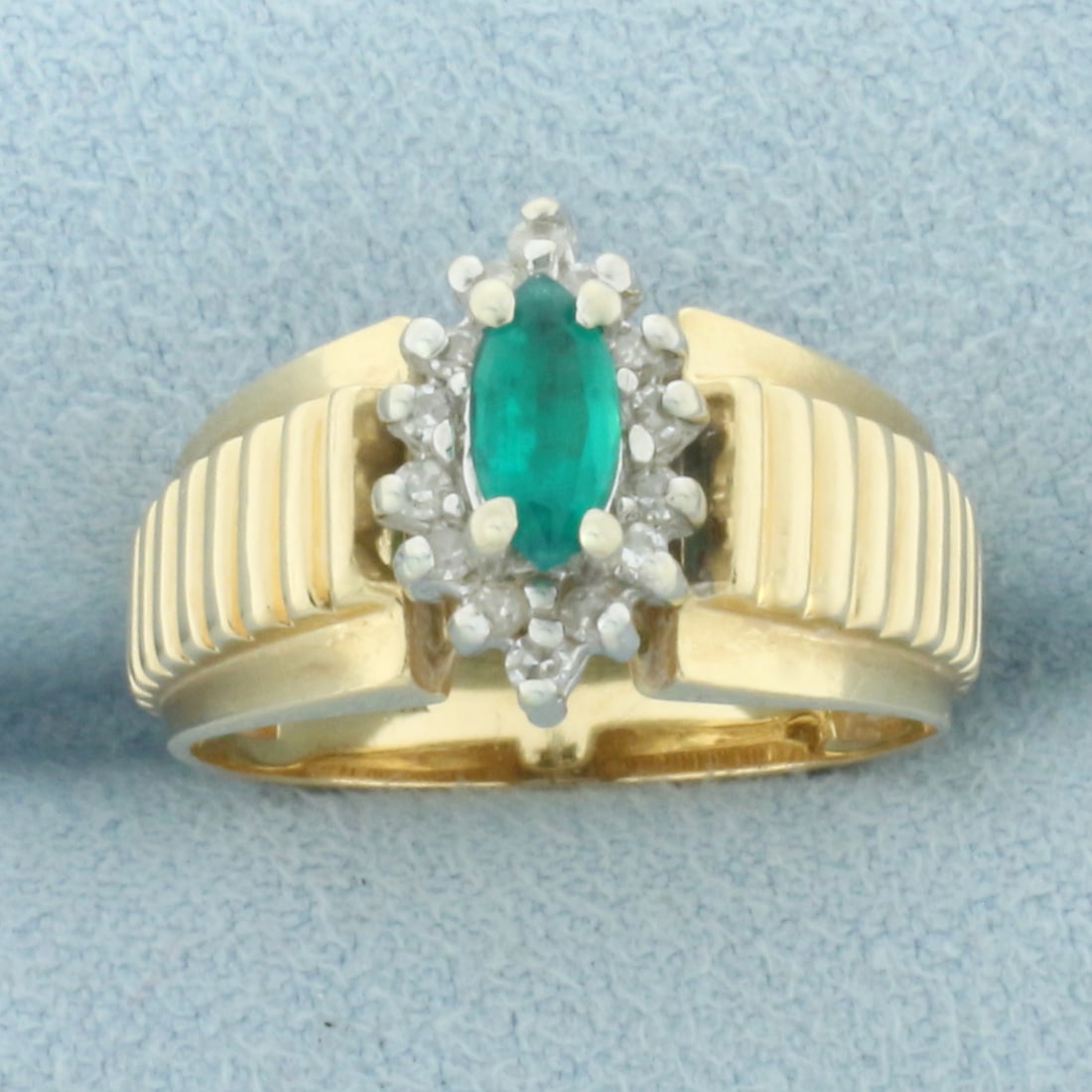 Emerald and Diamond Ring in 14k Yellow Gold: In 14k Yellow Gold. Contains one high quality natural 7mmx3.3mm marquise Emerald gemstone with vibrant color and excellent clarity. Also contains fourteen .01ct diamonds, SI clarity/H color. 12mm wide