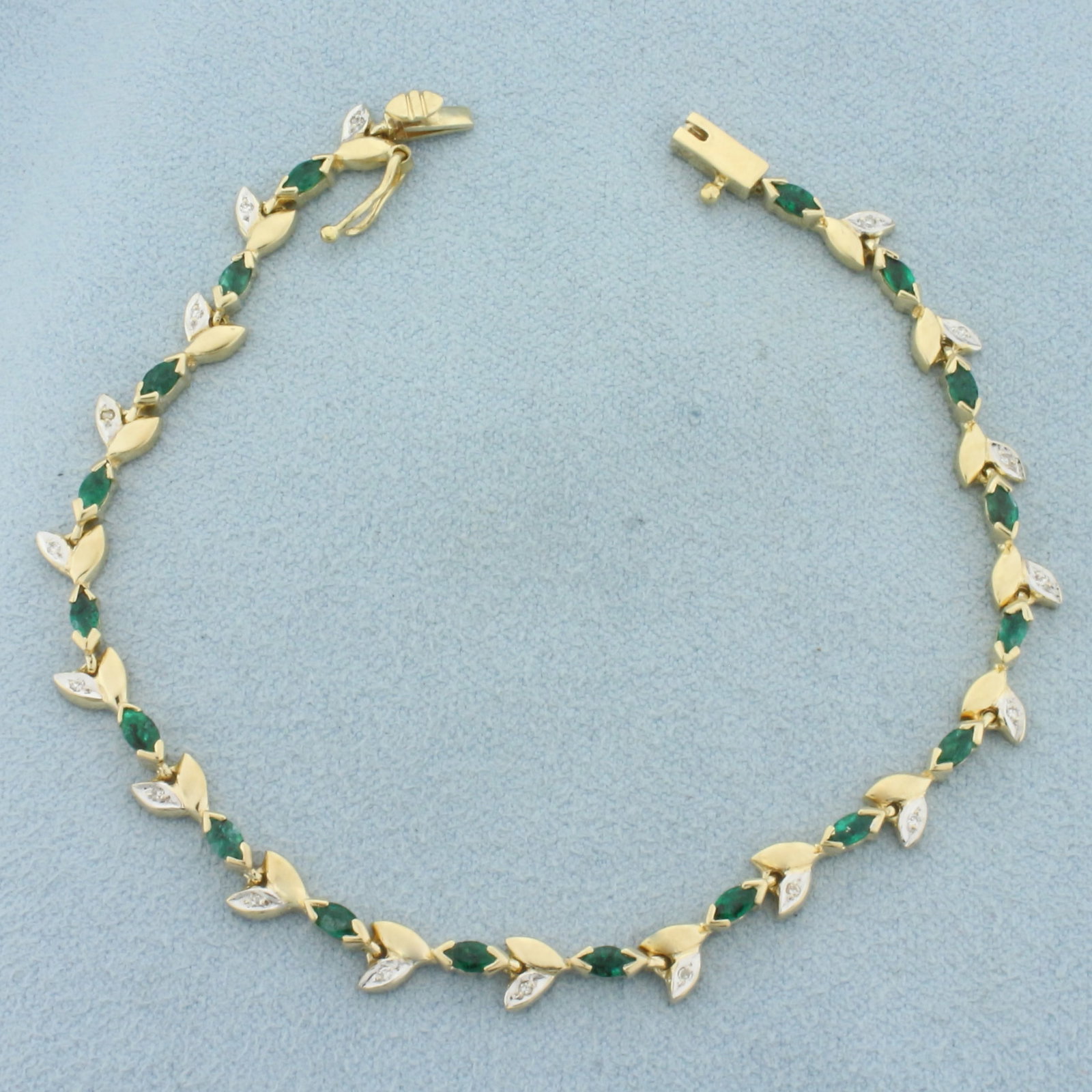 Emerald and Diamond Nature Leaf Tennis Bracelet in 14k Yellow Gold: In 14k Yellow Gold. Contains seventeen 4mm high quality natural Emerald gemstones with intense color. Also contains eighteen high quality 1/2pt diamonds. 7 inches long. Slide clasp with safety latch. 