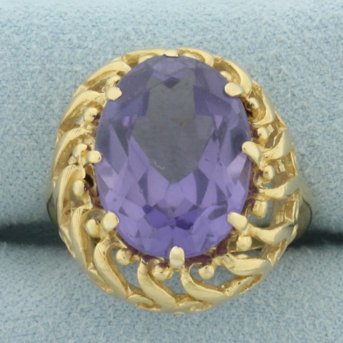 Color Changing Lab Alexandrite Ring in 14k Yellow Gold: In 14k Yellow Gold. Contains one 16x12mm high quality oval cut color changing Lab Alexandrite gemstone, approximately 9cts, with dramatic color shift from purple to pink. Size 6.5. 9.2g.