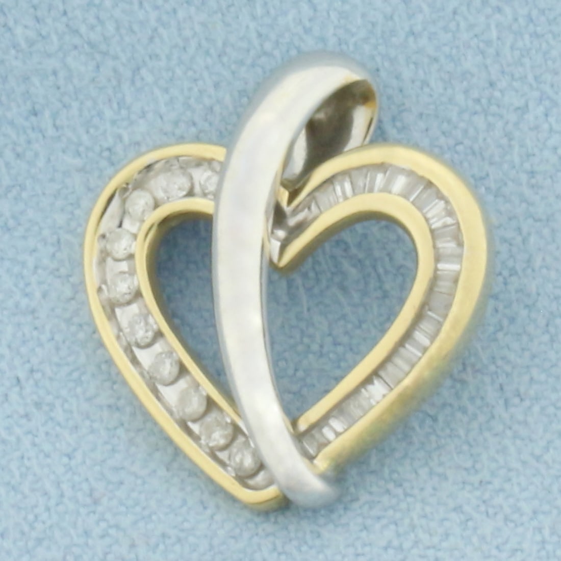 Two Tone Diamond Heart Pendant in 14k White and Yellow Gold: In 14k White and Yellow Gold. Contains ten .01ct round and 21 baguette high quality diamonds, I color/I clarity. 3/4 inch long and wide. 2.9g.