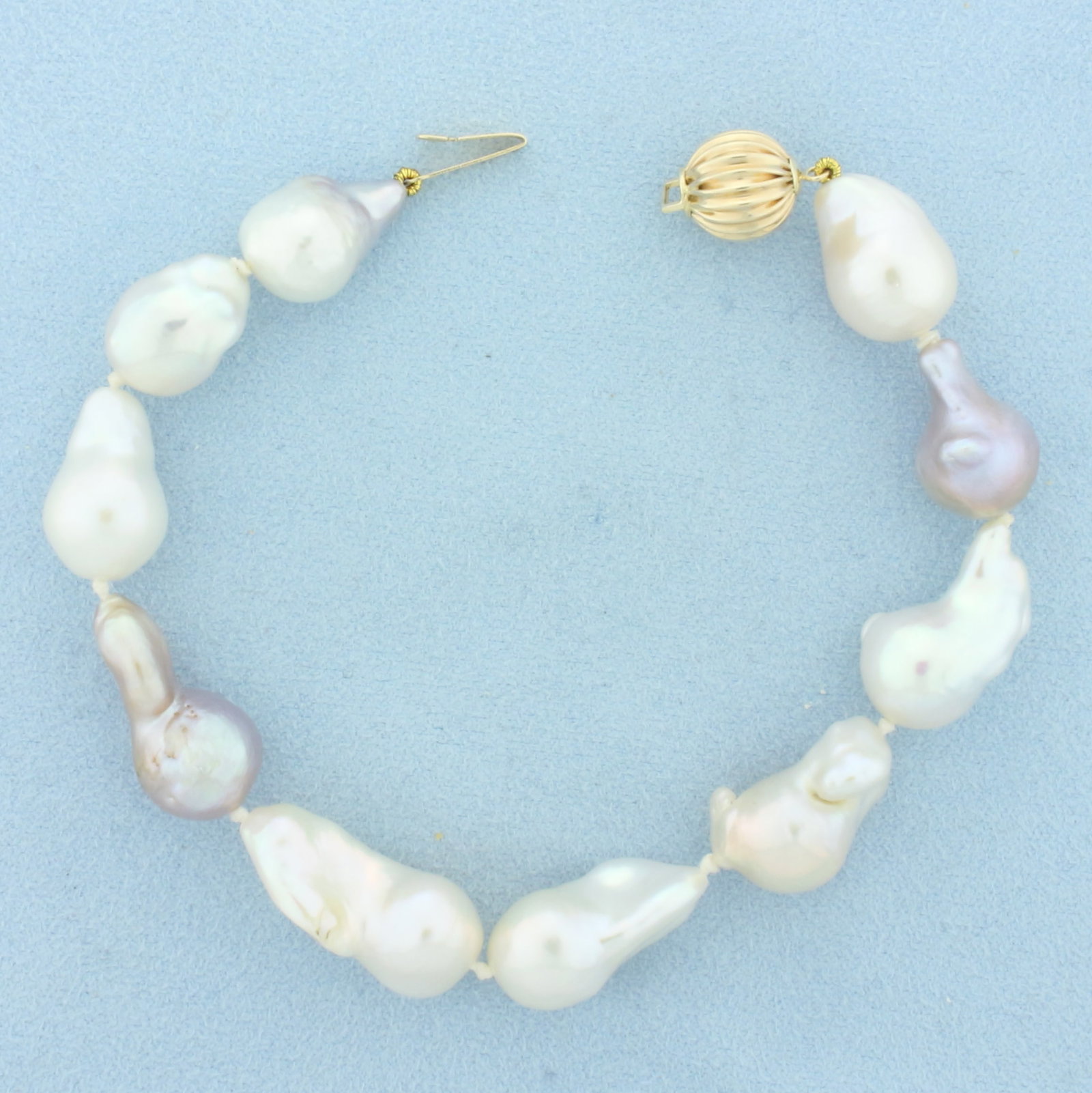 Baroque Multi Color Akoya Pearl Bracelet in 14k Yellow Gold: In 14k Yellow Gold. 8.25 inches long. Contains 11mm high quality baroque Akoya pearls with high luster and beautiful colors including cream, silver, and peacock. Hand knotted. Decorative bead clasp. 2