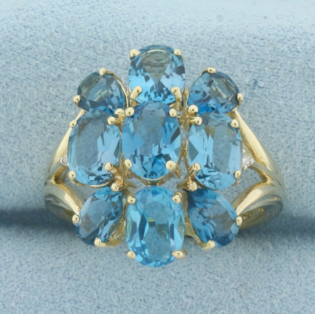 Swiss Blue Topaz Statement Ring in 10k Yellow Gold: In 10k Yellow Gold. Contains four 7x5mmoval and four 6x4mm pear high quality natural pear cut Swiss Blue Topaz gemstones with electric blue color and excellent clarity. 20mm wide at top of ring. Size 