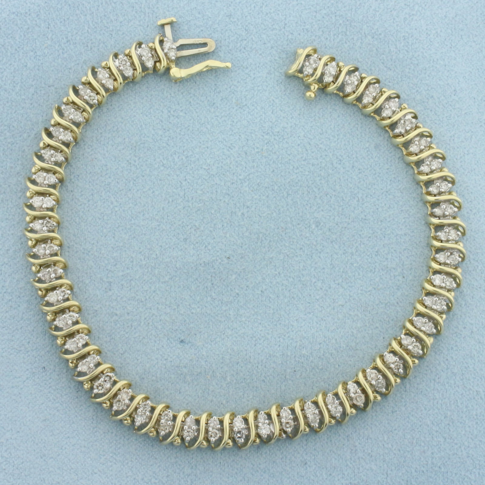 Diamond Tennis Bracelet in 10k Yellow Gold: In 10k Yellow Gold. Contains ninety-four high quality diamonds, 2ct TW, I color/I clarity. 7 1/8 inches long. 6.3mm wide. Concealed slide clasp with safety latch. 12.0g.