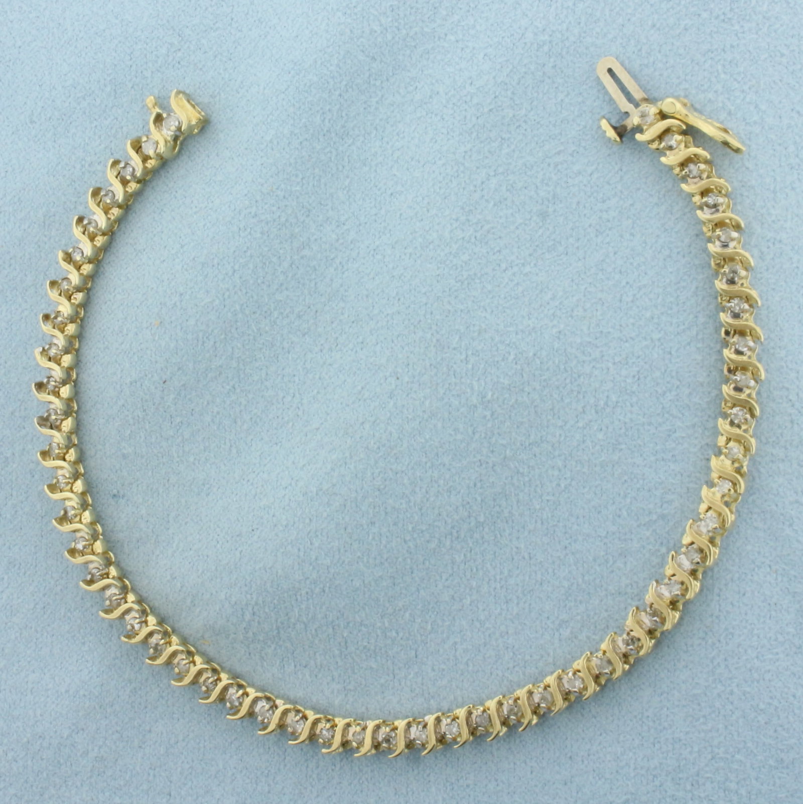 Diamond S-Link Tennis Bracelet in 14k Yellow Gold: In 14k Yellow Gold. Contains fifty-one high quality diamonds, 1ct TW, I color/I clarity. 7 1/4 inches long. 4mm wide. Concealed slide clasp with safety latch. 10.2g.
