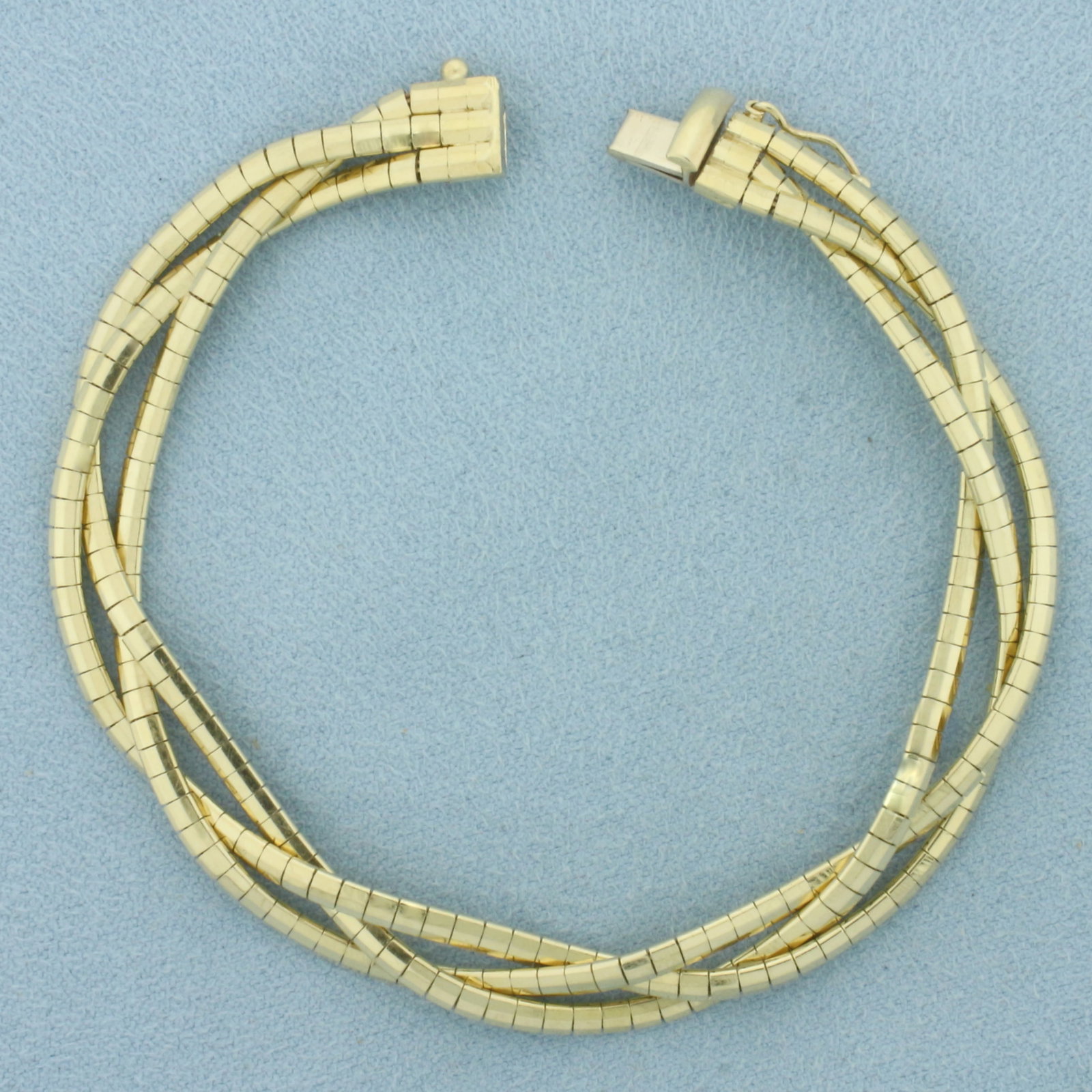 Italian Braided Omega Bracelet in 14k Yellow Gold: In 14k Yellow Gold. 7 1/4 inches long. 8mm wide. Made in Italy. Concealed slide clasp with safety latch. 20.2g.