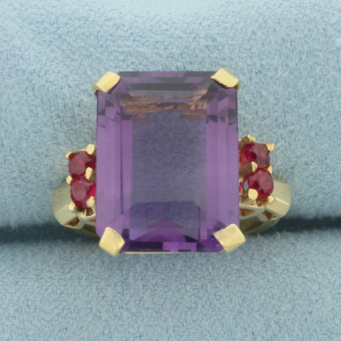 Amethyst and Ruby Statement Ring in 14k Yellow Gold: In 14k Yellow Gold. Contains one 16x12mm high quality emerald cut natural Amethyst gemstone, approximately 10cts, with vibrant color and excellent clarity. Also contains four 3mm high quality Ruby gem