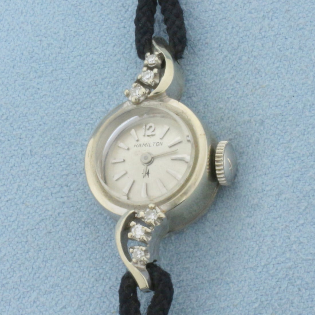 Ladies Vintage Hamilton Windup Watch in 14k White Gold: Solid 14k White Gold case, plated bracelet. Windup movement runs great. Minimal scratching on case, crystal, in great condition. Contains six .01ct high quality diamonds. 6 inches long. 15mm case. 8.0