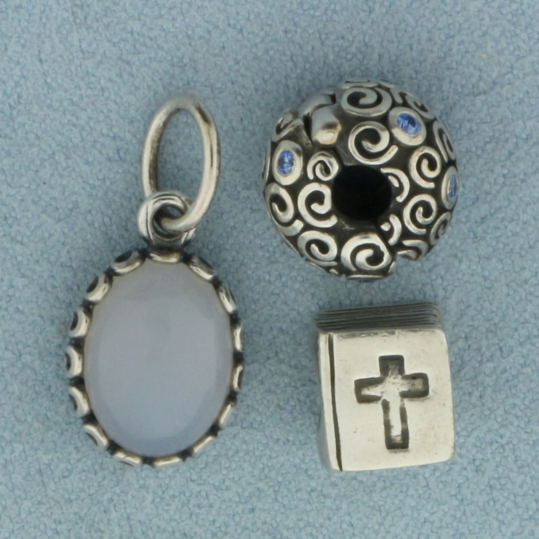 Pandora Charm Beads Set of 3 in Sterling Silver: In .925 Sterling Silver. Contains one Bible with cross, one dangle gemstone, and one hinged blue stone.