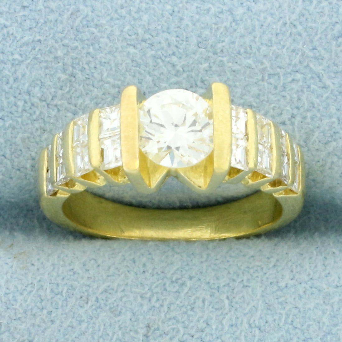 Tension Set Diamond Engagement Ring in 18K Yellow Gold: In 18K Yellow Gold. Center diamond is a very high quality 3/4ct Round Brilliant, VS2 clarity/F color, completely eye clean and great cut for amazing sparkle. Also contains sixteen princess diamonds in