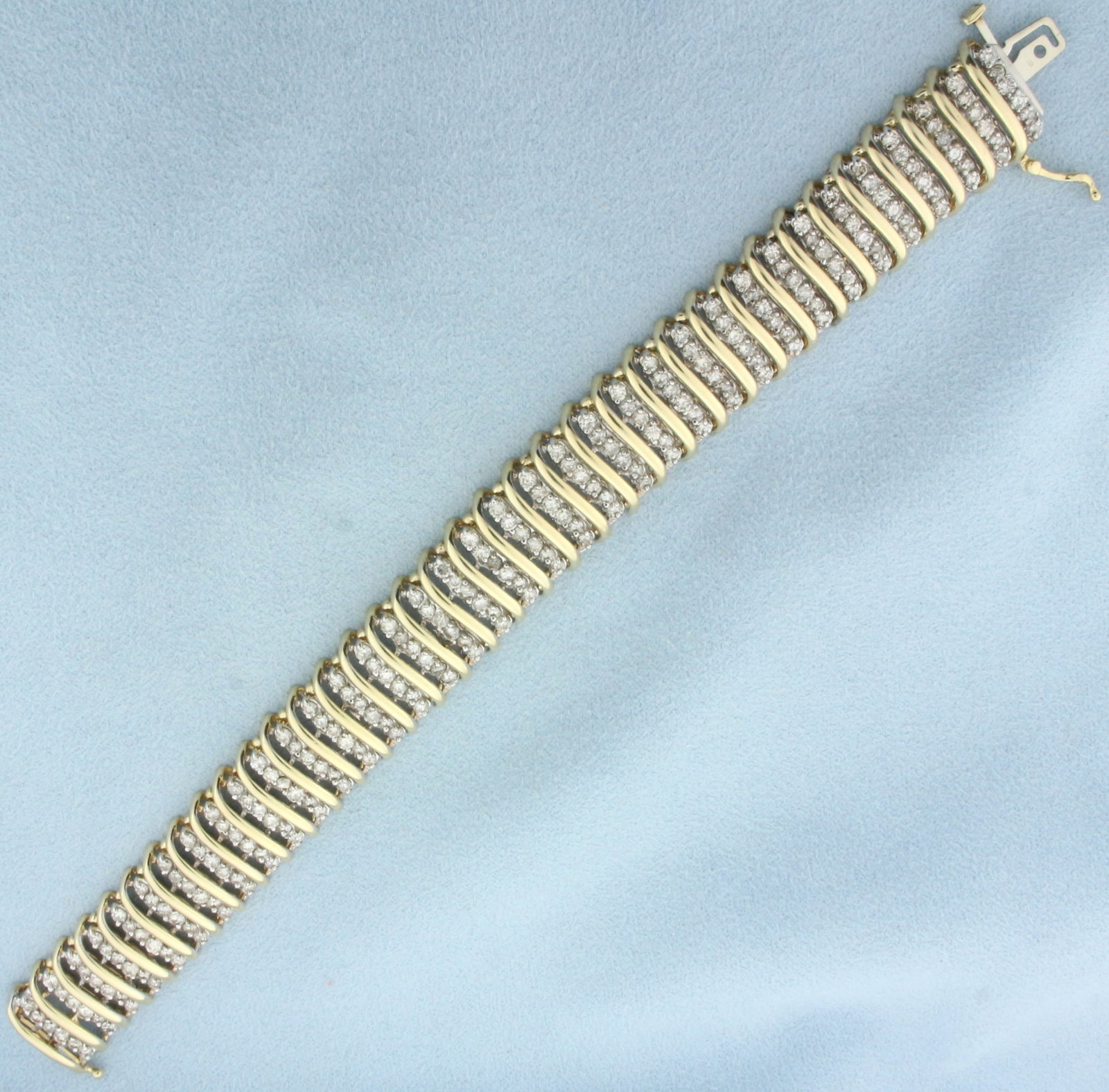 8ct Diamond Wide Tennis Bracelet in 10k Yellow Gold: In 10k yellow gold. Contains 216 high quality diamonds, 8ct TW ,SI2 clarity/J color. Measures 7 inches long, 16mm wide. Concealed slide continuous closure with safety latch. 30.2g.