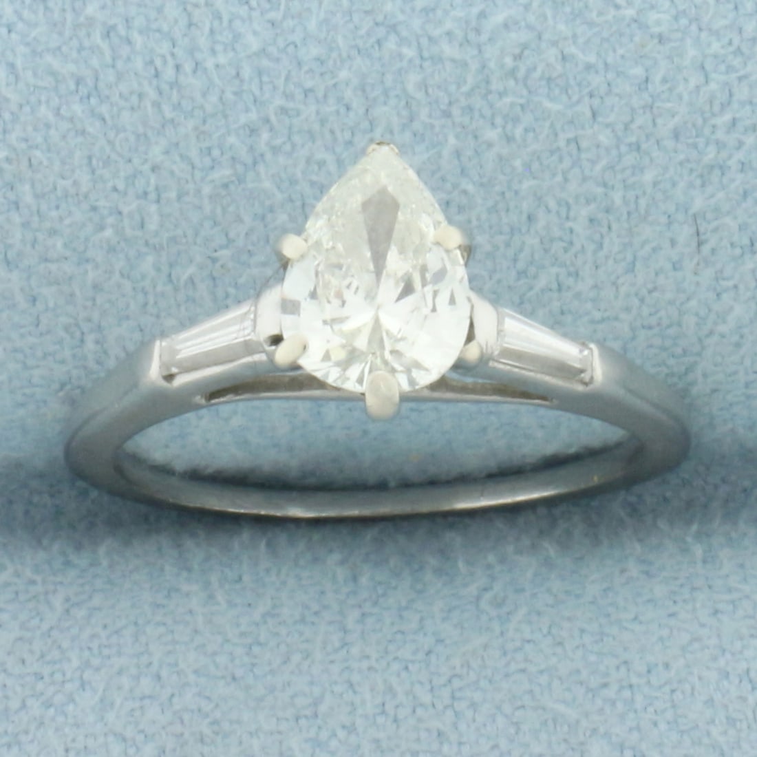 Pear and Baguette Diamond Engagement Ring in 14k White Gold: In 14k white gold. Center diamond is a high quality 3/4ct pear cut pear cut diamonds, SI clarity/H color, eye clean. Accented by 2 tapered baguette cut .05ct diamonds of similar high quality. Size 4.5
