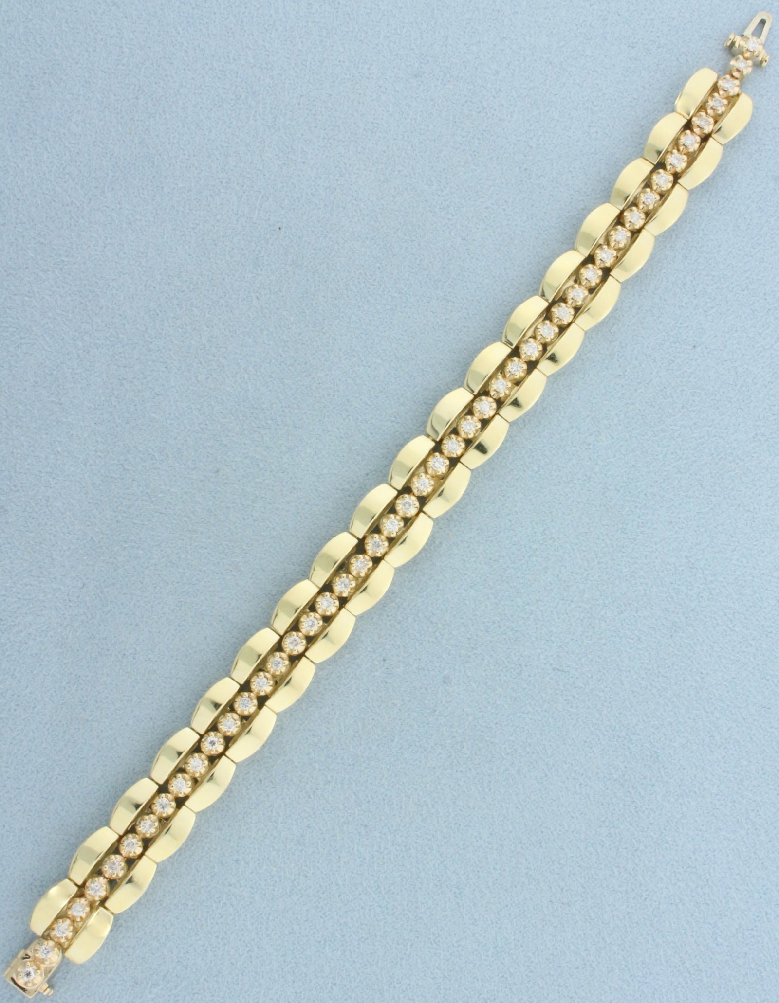 Diamond Tennis Bracelet in Tank Track Jacket in 14k Yellow Gold: In 14k yellow gold. Contains 48 high quality round brilliant diamonds, 1ct TW, SI clarity/H color. Tennis bracelet is set into tank track jacket (secured at each end). 6 1/2 inches long x 10mm wide. C