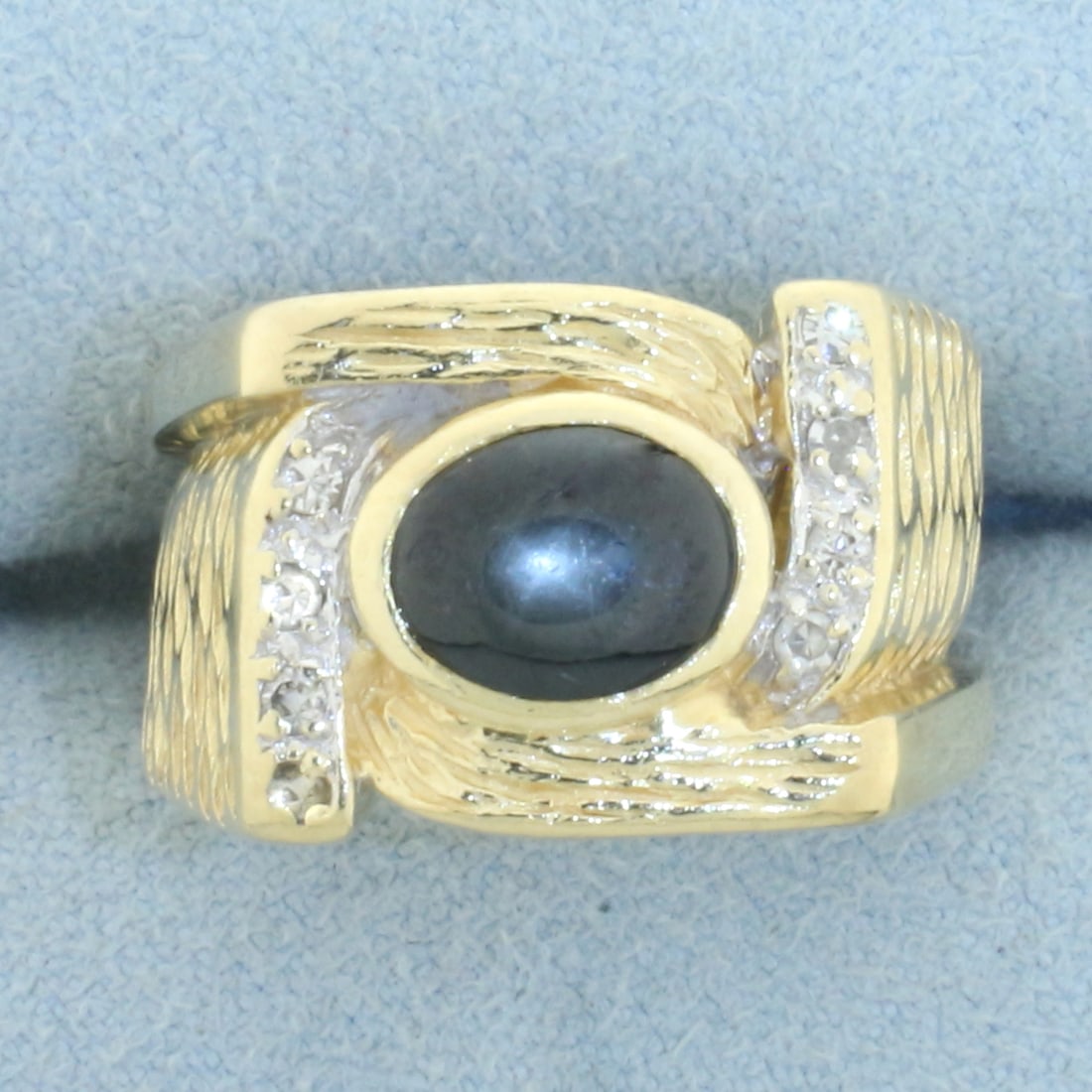Natural Black Star Sapphire and Diamond Ring in 14k Yellow Gold: In 14k yellow gold. Contains 1 high quality natural 8mm by 6mm black Star Sapphire gemstone with visible star under light. Also contains 8 high quality .01ct diamonds, SI clarity/H color. Size: 6.5. 9