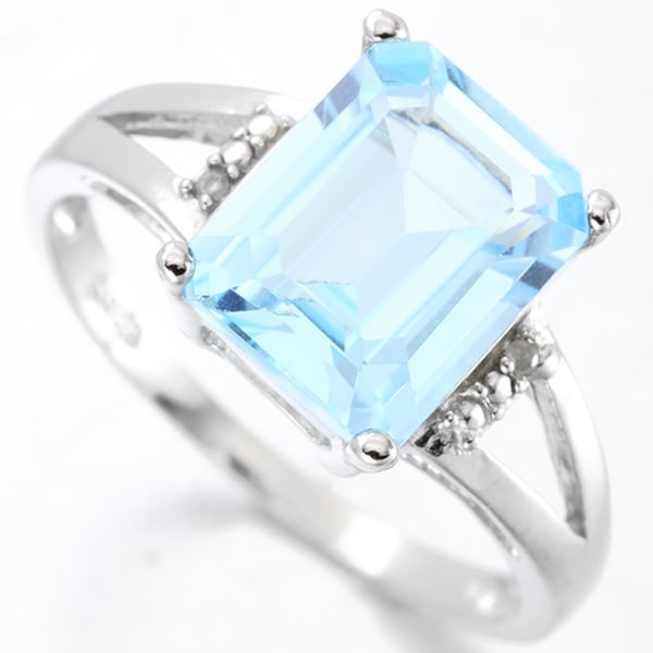 Emerald Cut Blue Topaz & Diamond Split Shank Ring in Sterling Silver: In platinum over .925 sterling silver. Contains one emerald cut blue topaz gemstone, 3.7cts, accented with two genuine diamonds, .01ctw. Size 7. 2.5g