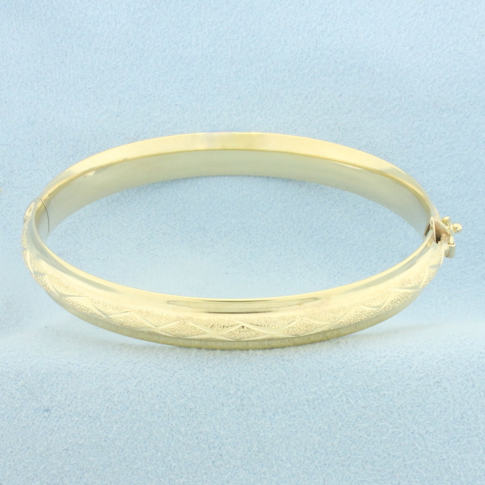 Hinged Bangle Bracelet in 14k Yellow Gold: In 14k Yellow Gold. 8mm wide. Hinged design with slide closure and safety latch. 12.2g.