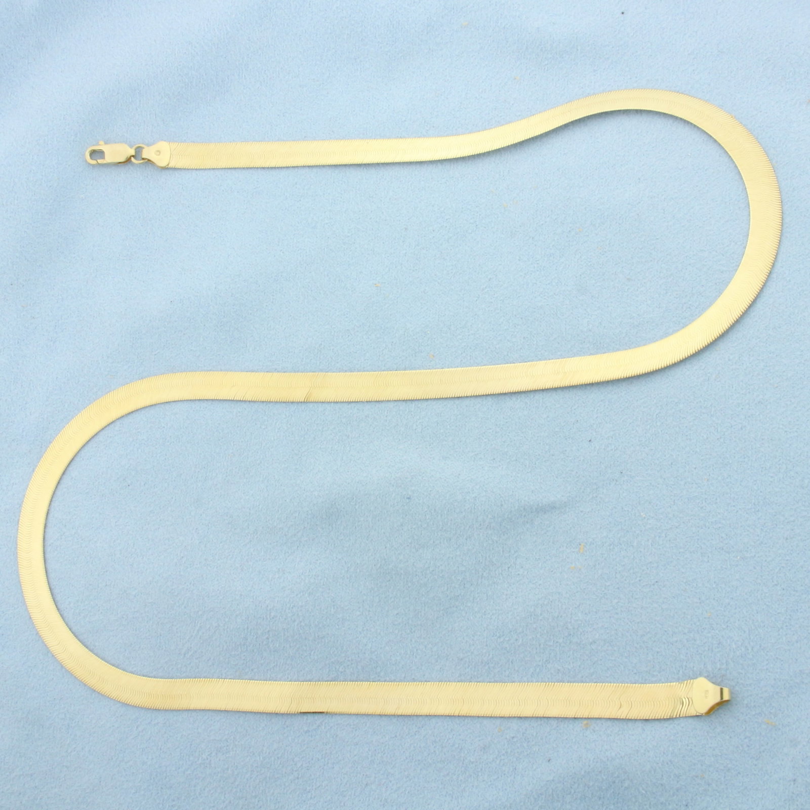 20 Inch Italian Liquid Gold Herringbone Chain Necklace in 14k Yellow Gold: In 14k Yellow Gold. 20 inches long. 6mm wide. Italian made. Lobster clasp. 12.5g.