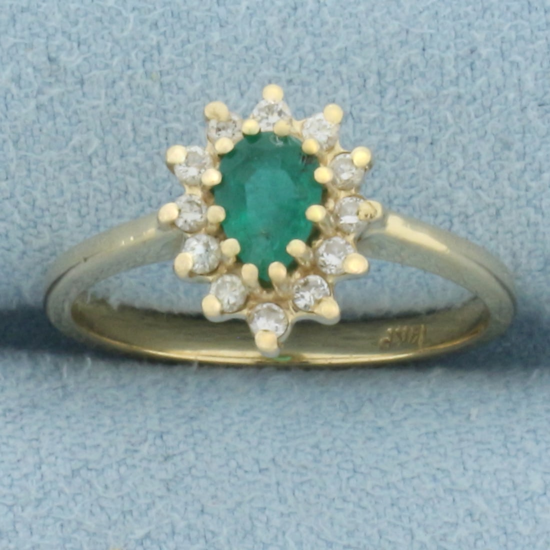 Emerald and Diamond Halo Ring in 14k Yellow Gold: In 14k Yellow Gold. Contains one 6x4mm high quality pear natural Emerald gemstone with vibrant color. Also contains twelve .01ct high quality diamonds, SI clarity/H color. 10.6mm wide at top of ring. 