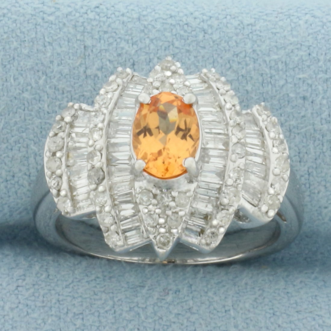 Spessartite Garnet and Diamond Ring in 14k White Gold: In 14k White Gold. Contains one 7x5mm high quality oval cut natural Spessartite Garnet gemstone, approximately 1ct TW, with vibrant orange color and excellent clarity. Also contains forty-two baguette