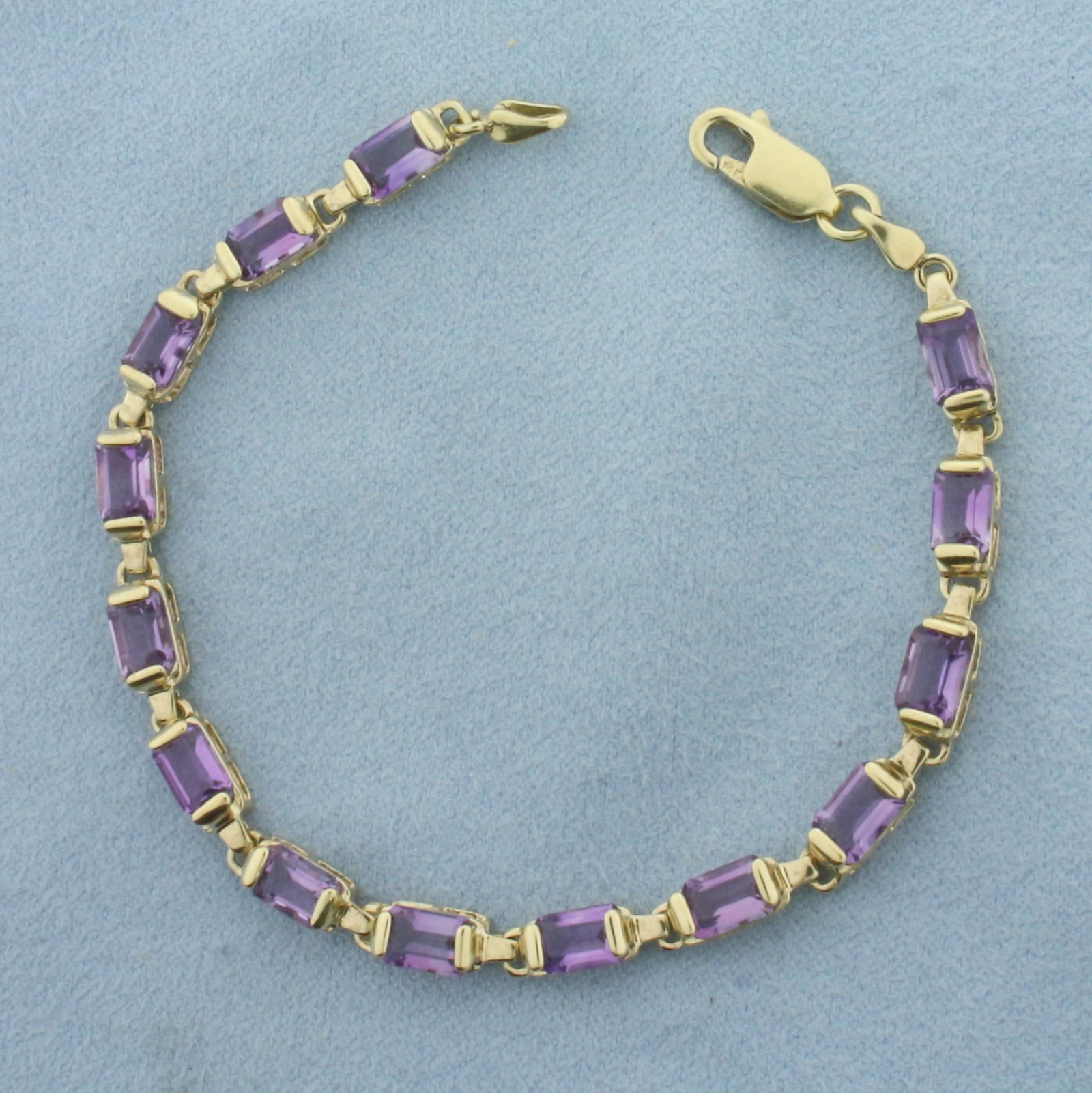 Amethyst Tennis Bracelet in 14k Yellow Gold: In 14k Yellow Gold. 7 inches long. 4.5mm wide. Contains 14 high quality natural 6mm emerald cut Amethyst gemstones, 7 carat total weight, with vibrant color and excellent clarity. Lobster clasp. 8.3g.