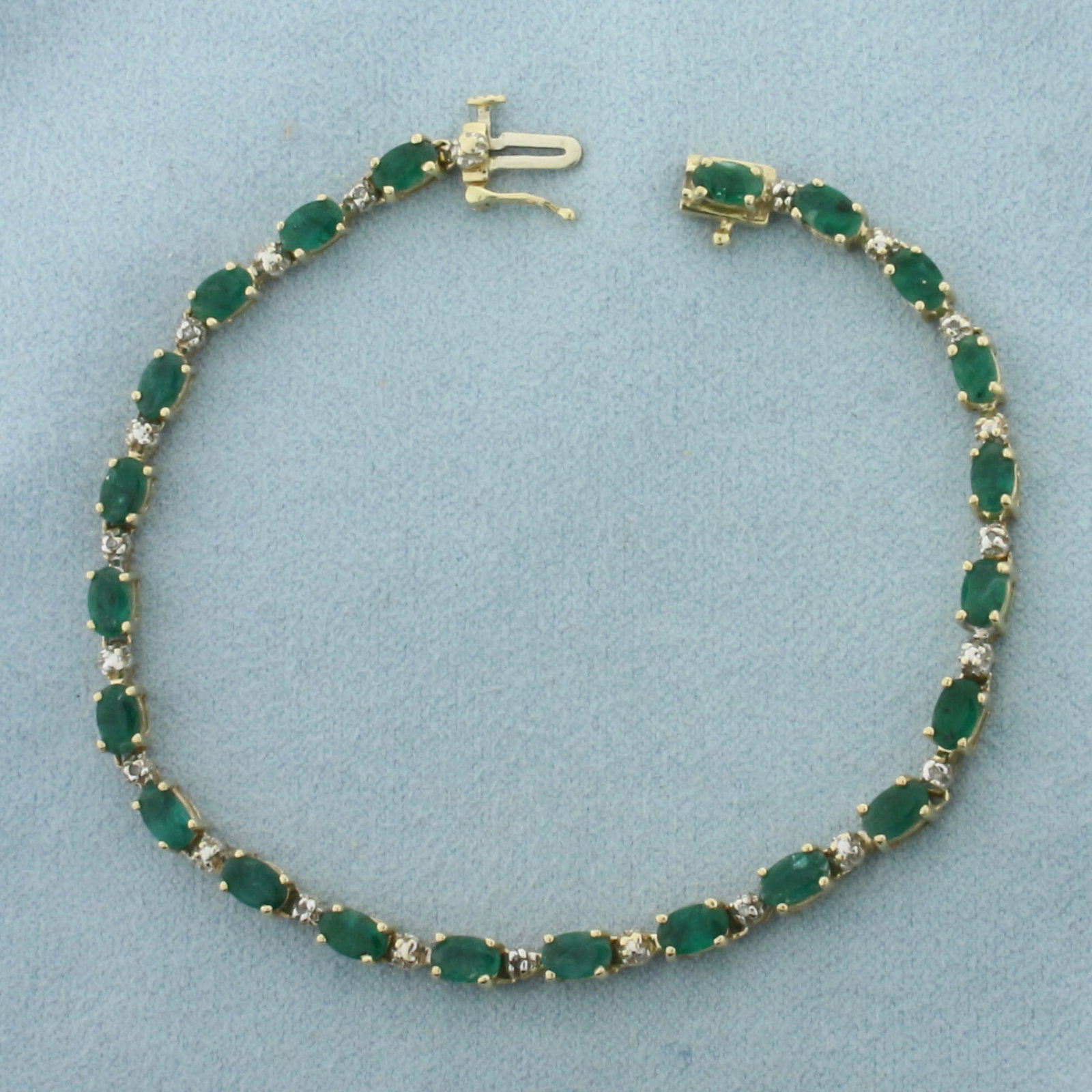 Emerald and Diamond Tennis Bracelet in 14k Yellow Gold: In 14k Yellow Gold. Contains twenty-two 5mm high quality natural Emerald gemstones, approximately 5.5ct TW, with intense color. Also contains eleven high quality 1/2pt diamonds. 7 1/8 inches long. 3.4