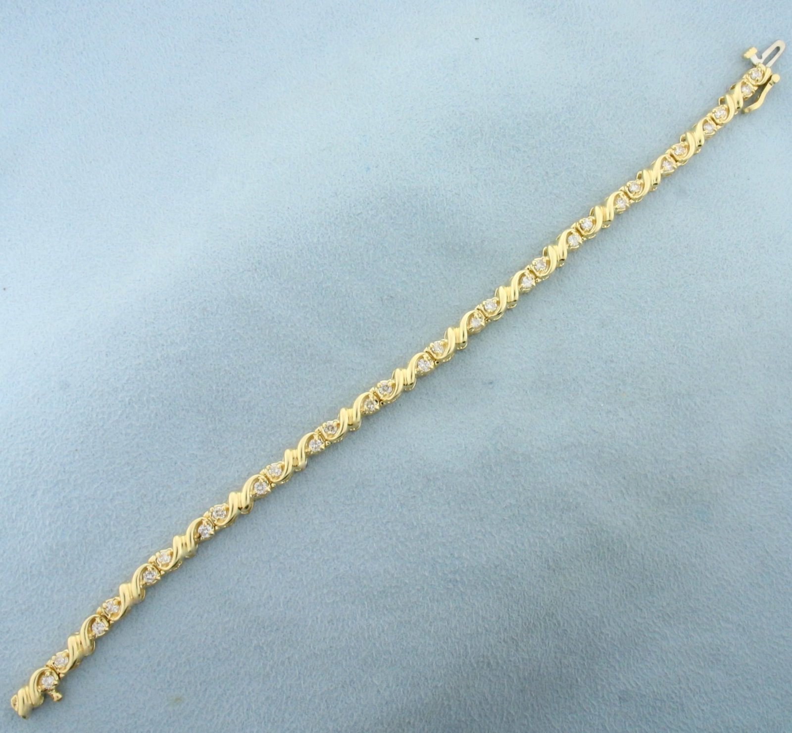 Unique Scroll Deisgn Diamond Tennis Bracelet in 14K Yellow Gold: In 14K Yellow Gold. Contains thirty high quality Diamonds, 1ct TW, VS clarity/H color. Safety clasp. 7 inches long. 4.6mm wide. 12.8g