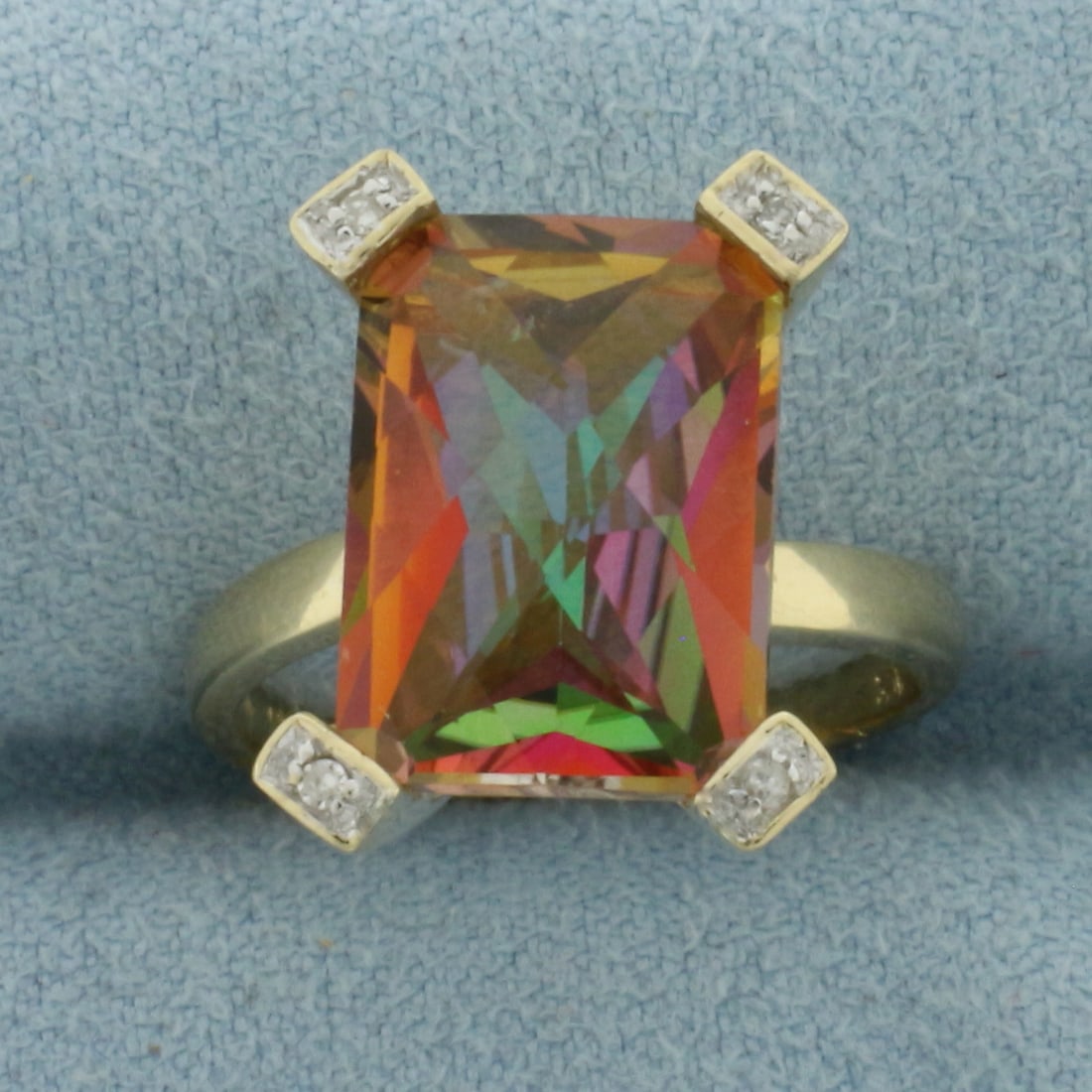 Mystic Topaz and Diamond Ring in 10k Yellow Gold: In 10k Yellow Gold. Contains one 14x10mm high quality fancy checkerboard cut Mystic Topaz gemstone with vibrant color. Also contains eight high quality 1/2pt diamonds. Size 6.5. 4.3g/