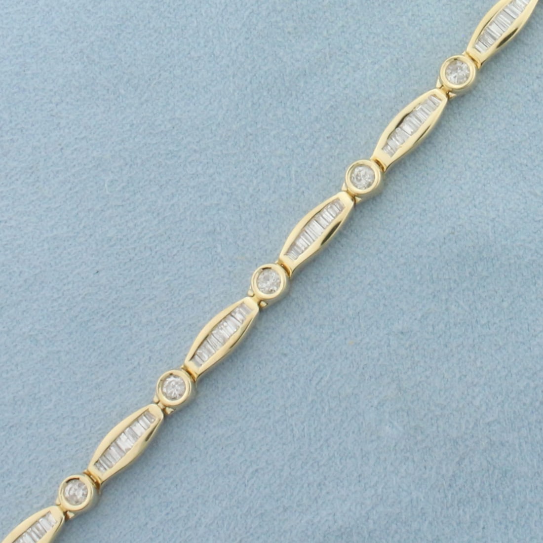 Diamond Tennis Bracelet in 14k Yellow Gold: In 14k Yellow Gold. 6.75 inches long. 4.3mm wide. Contains 11 high quality .09ct diamonds, SI clarity/H color. Also contains 99 high quality .01ct baguette diamonds of similar high quality. 2ct TW of 