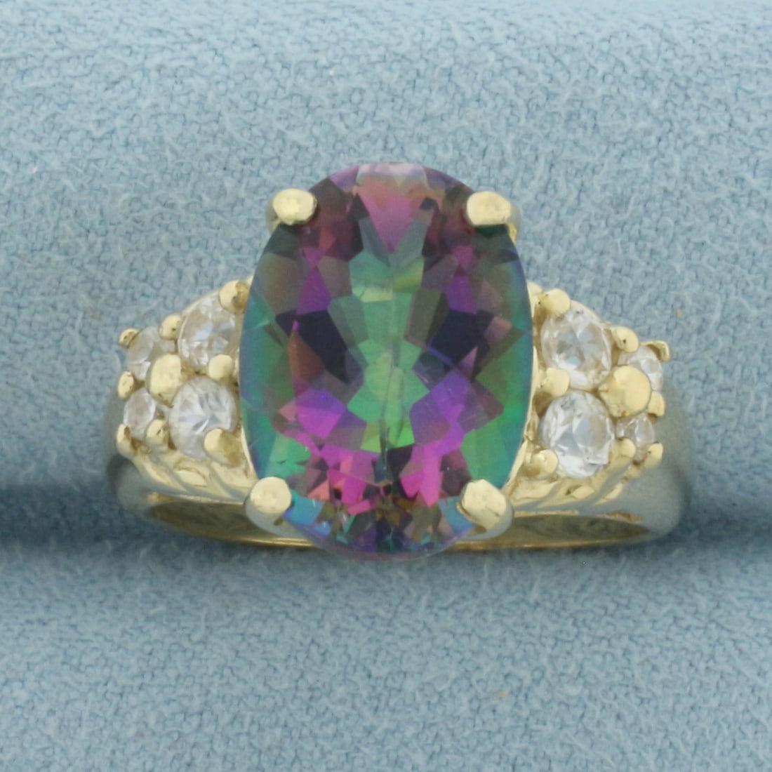 Mystic Topaz and White Sapphire Ring in 10k Yellow Gold: In 10k Yellow Gold. Contains one 14x10mm high quality oval cut Mystic Topaz gemstone with vibrant color and excellent clarity Also contains four 3mm and four 2mm high quality natural White Sapphire ge
