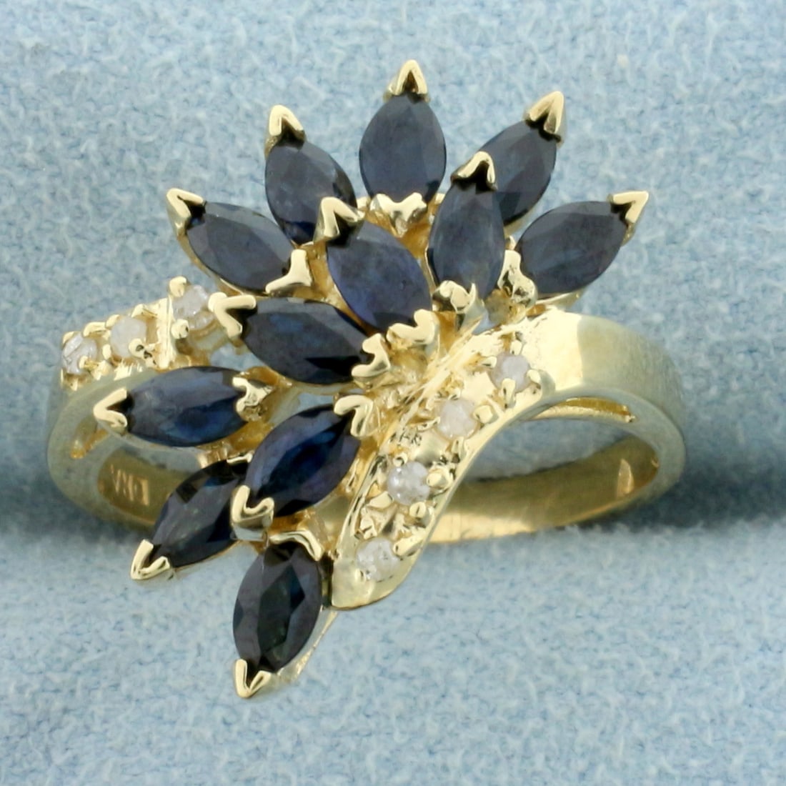 Vintage Natural Sapphire and Diamond Ring in 10K Yellow Gold: In 10K Yellow Gold. Contains twelve high quality natural 1/4ct marquise cut Sapphire gemstones with deep blue color and excellent clarity. Also contains seven high quality .01ct round Diamonds, I colo