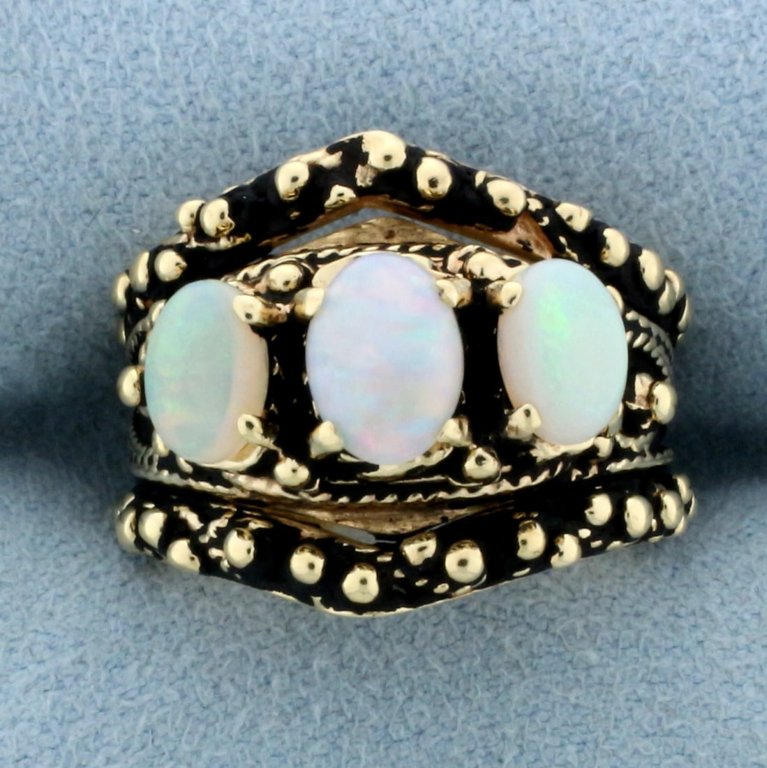 Vintage Opal Ring in 14k Yellow Gold: In 14k yellow gold. Contains one 7x5.5 and two 6x4mm high quality natural opal gemstones with flashes of yellow, orange, red, blue, and green. Size: 5. 10.0g.